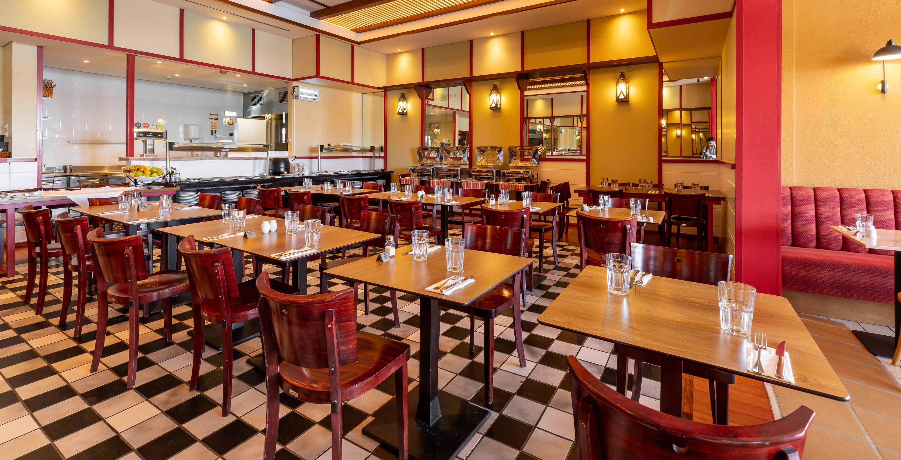 Das Restaurant Luigi im 5-Sterne-Resort auf Porto Santo hat dunkle Tische und Stühle mit roten Akzenten.