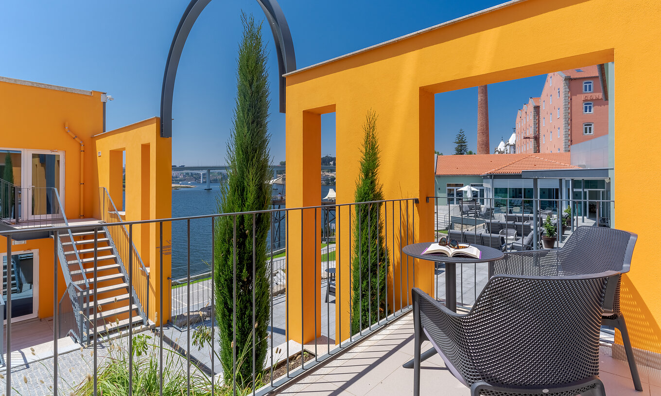 Das River View Zimmer im Pestana Douro Riverside hat einen Balkon mit Tisch und Stühlen