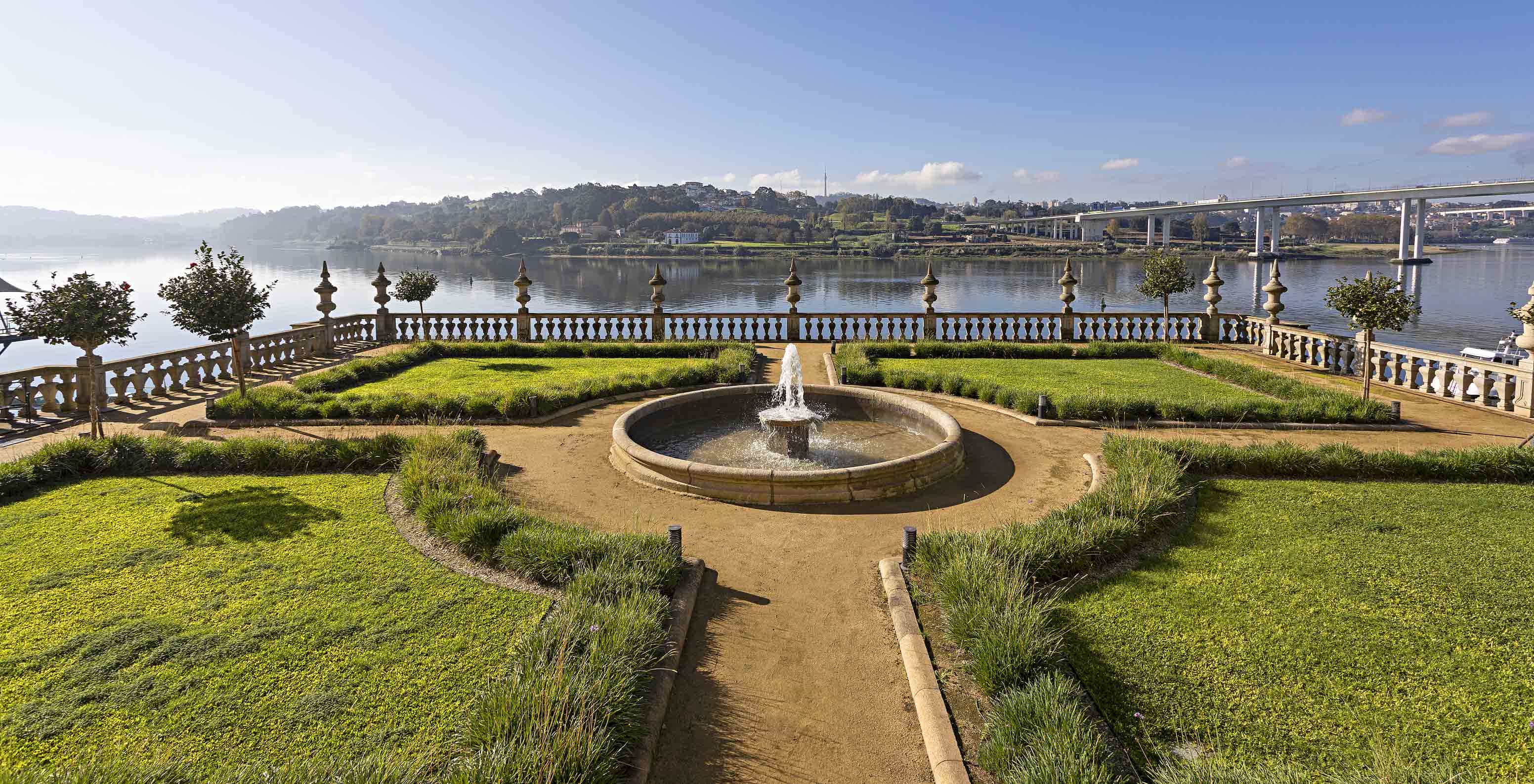 Blick auf die Gärten des Pestana Palácio do Freixo, mit einem Brunnen in der Mitte und dem Douro im Hintergrund