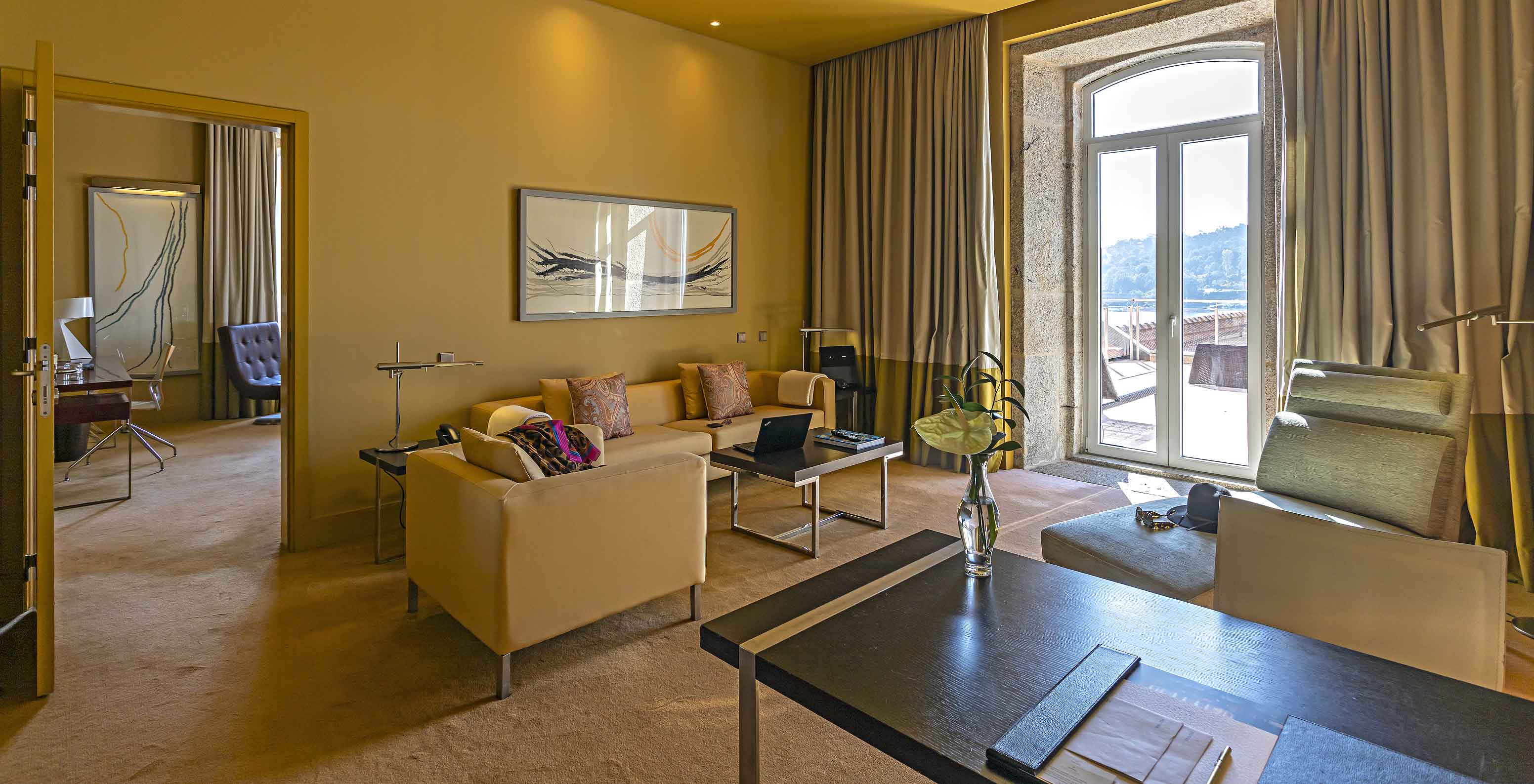 Die Suite Nasoni verfügt über ein Wohnzimmer mit sofas, Schreibtisch und einem Steinfenster zum Balkon