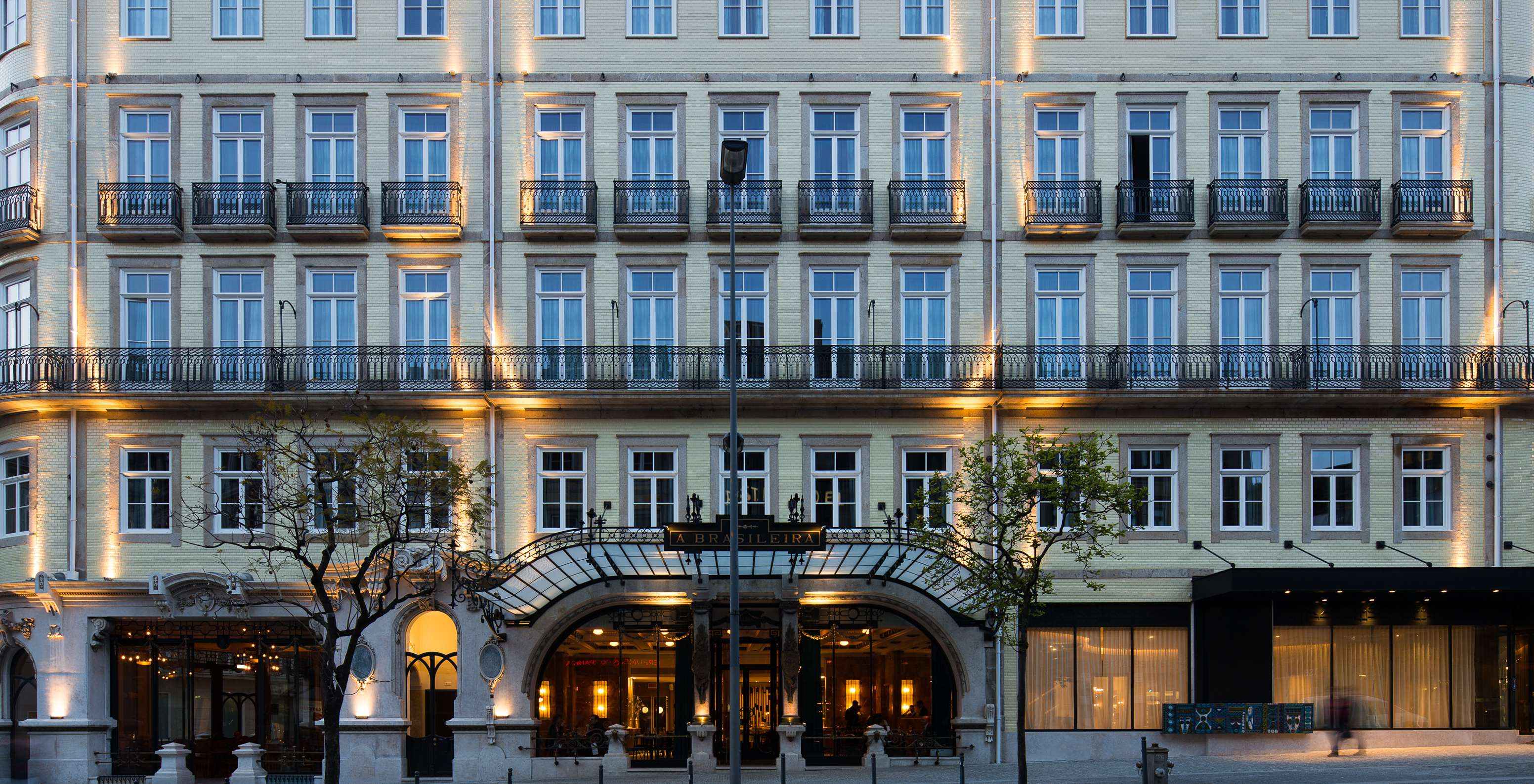 Die beleuchtete Fassade des Hotels Pestana Porto - A Brasileira zeigt beeindruckende Architektur mit klassischen Details