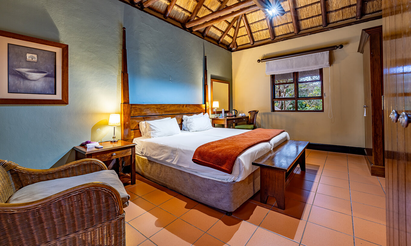 Das Klassische Zimmer im Pestana Kruger Lodge hat zwei Einzelbetten, einen Stuhl und Holzmobiliar