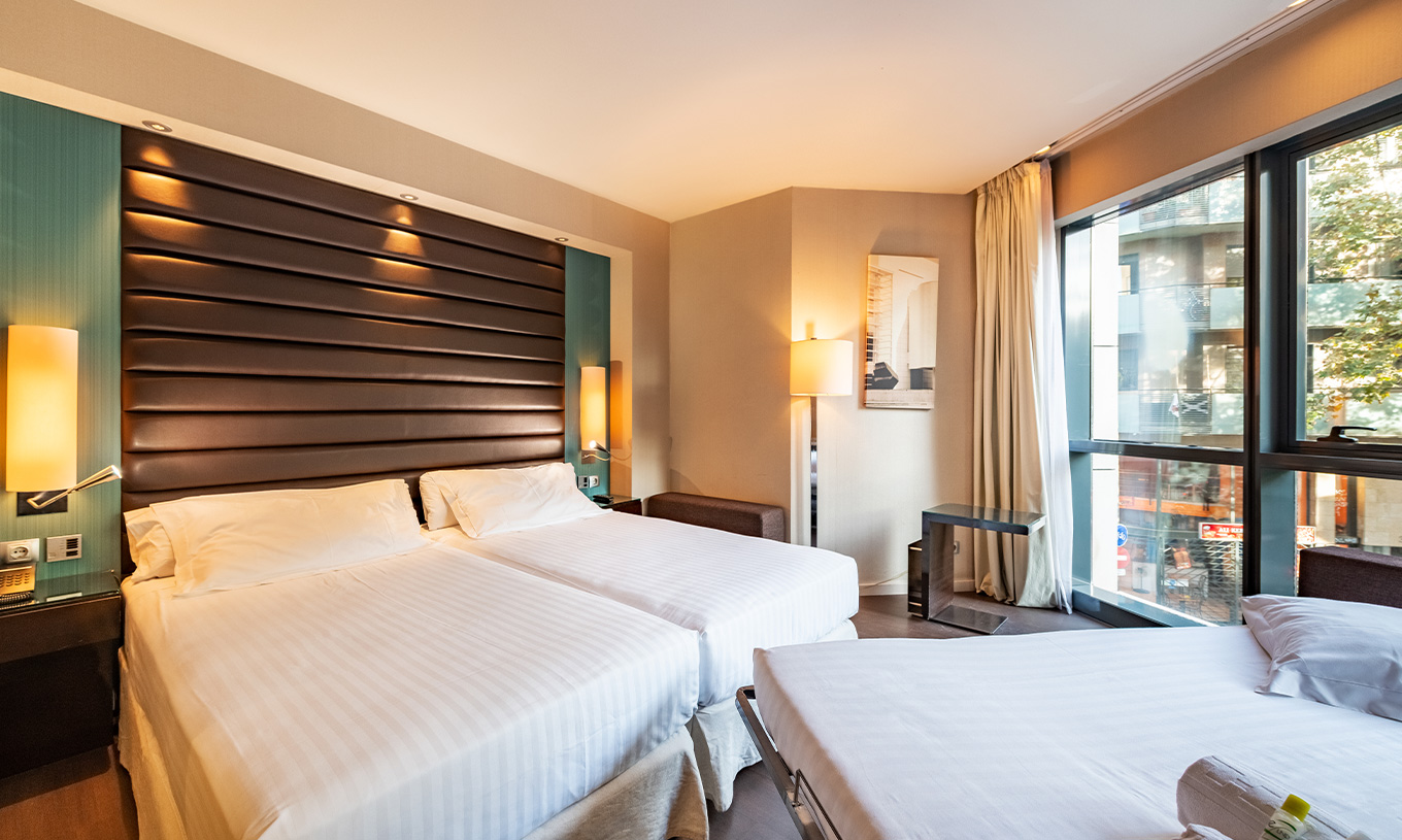 Das Superior Familienzimmer im Pestana Arena Barcelona hat ein großes Fenster, zwei Einzelbetten und ein Zusatzbett