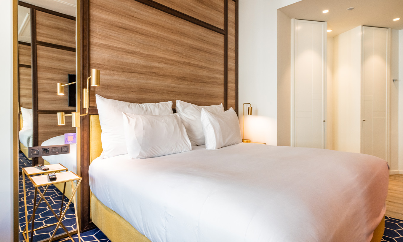 Das Fantastic 7 Zimmer im Pestana CR7 Gran Vía Madrid hat ein Doppelbett mit Nachttisch, Lampen, Spiegel und Schränke