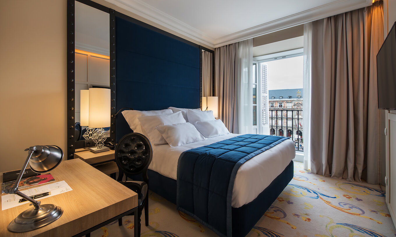 Das Superior Plaza Mayor im Pestana Plaza Mayor Madrid hat ein Bett, eine Lampe auf dem Nachttisch und ein Fenster