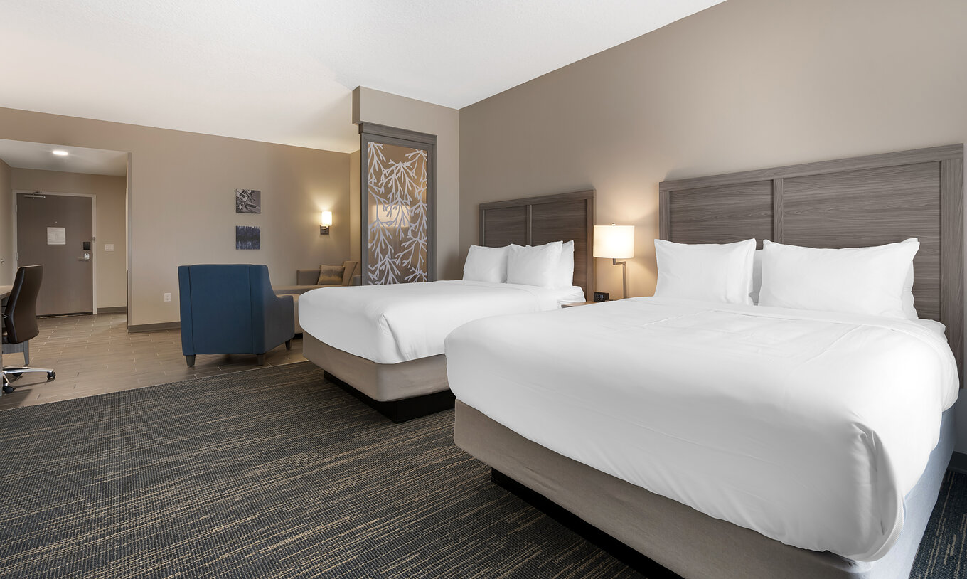 Die Master Duplex Queen-Suite im Pestana Orlando Suites Lake Buena Vista hat zwei Doppelbetten und einen Sessel