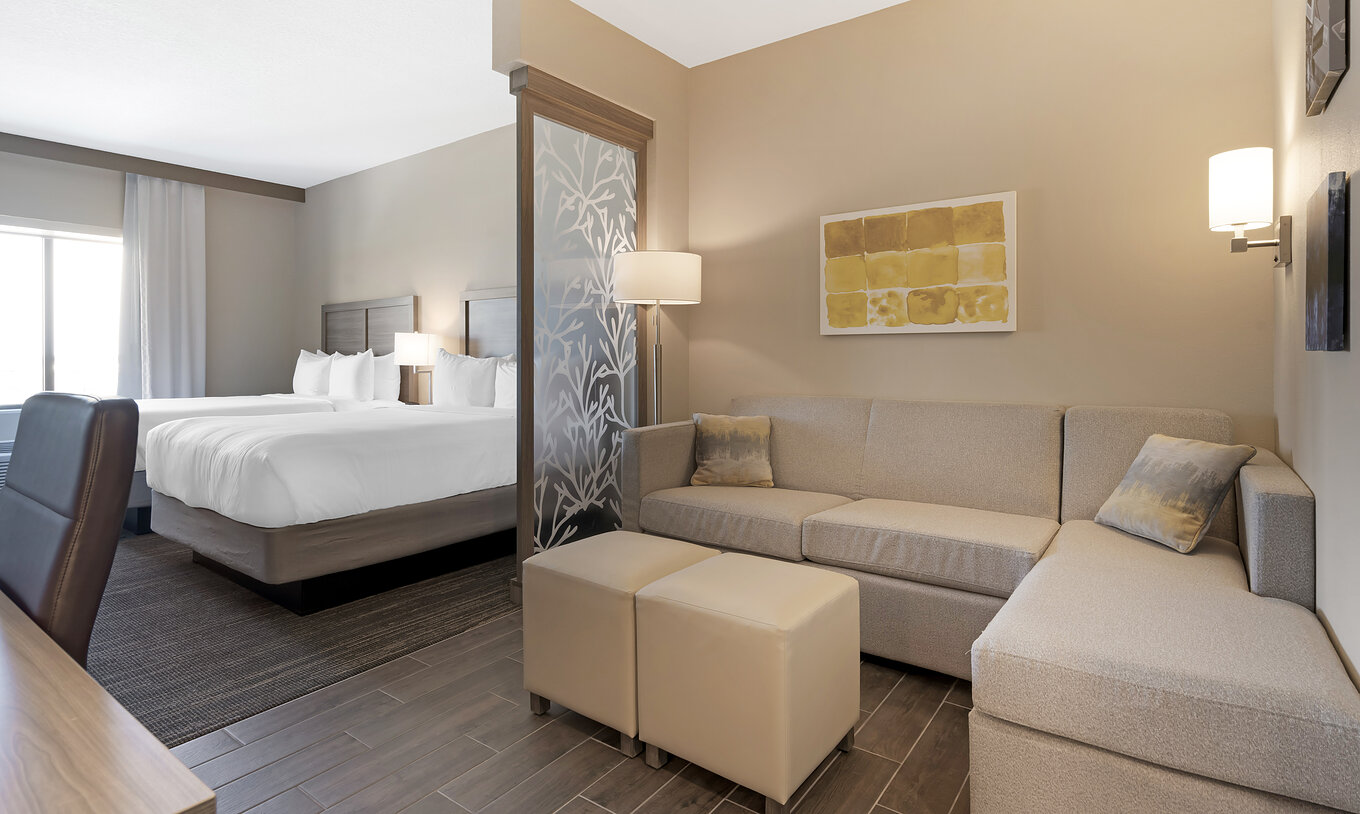 Die Queen Duplex-Suite im Pestana Orlando Suites Lake Buena Vista hat zwei Doppelbetten, Schreibtisch, Sofa und Lampe