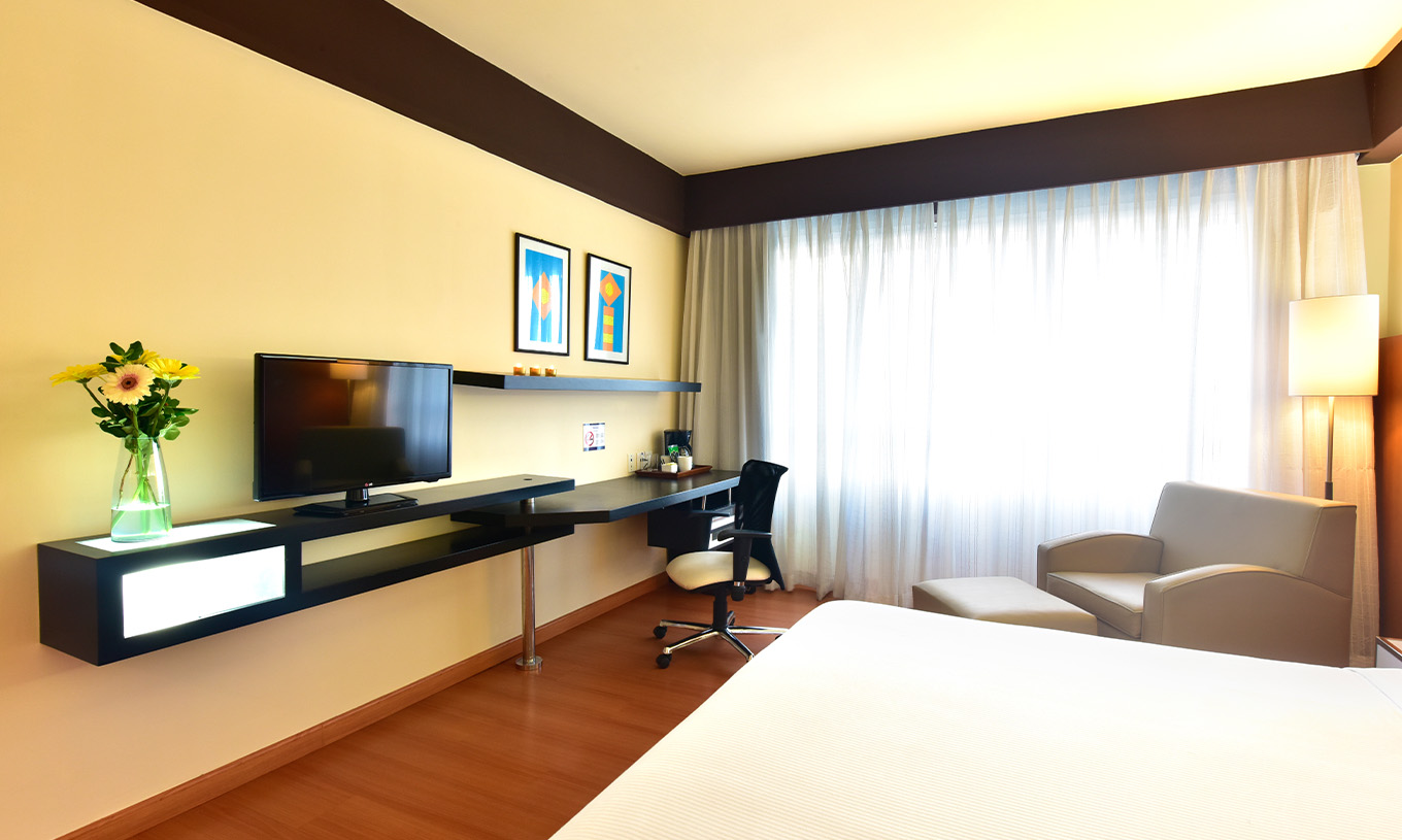 Der Twin Superior im Pestana Caracas hat einen Fernseher am Fuß des Bettes, einen Sessel, einen Schreibtisch und ein Fenster