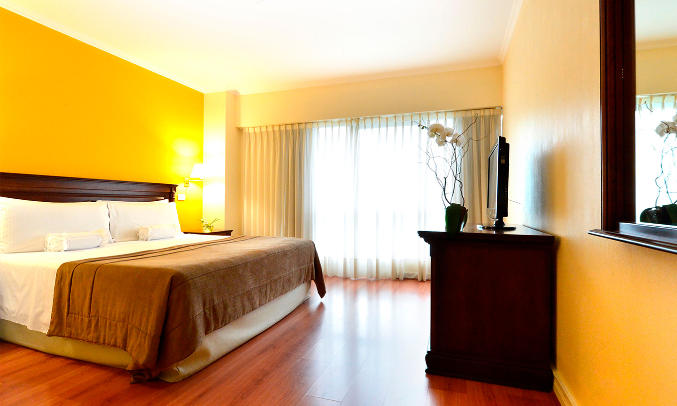 The Queen Superior Room at Pestana Buenos Aires has a double bed, a TV, a mirror, and a bedside table with a lamp