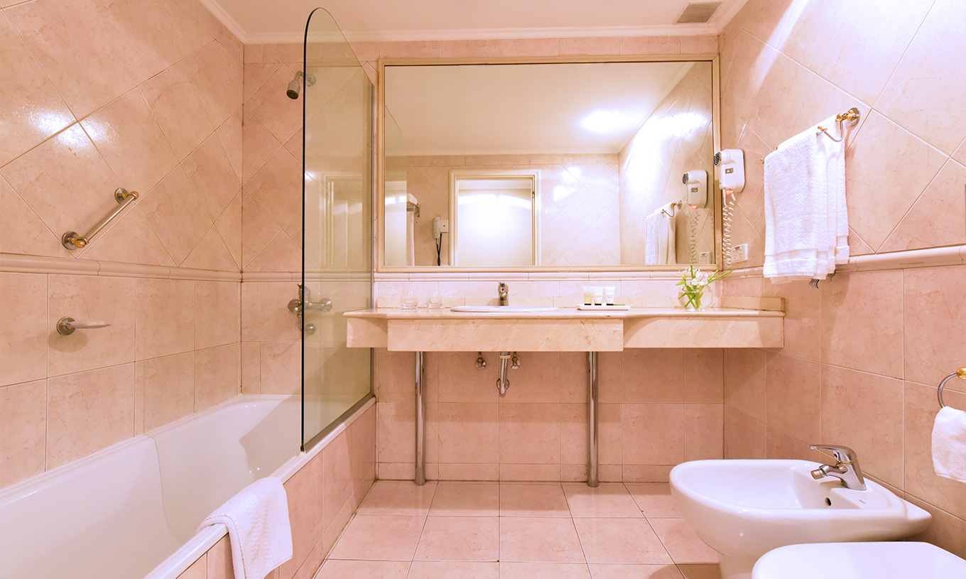 The Twin Superior Room at Pestana Buenos Aires has a bathroom with a sink, mirror, and a bathtub with a shower