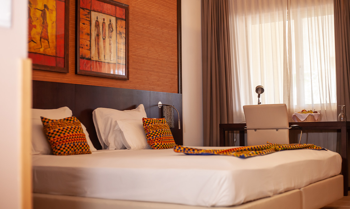 The Premium room at Pestana Tropico features a double bed, desk, and artistic walls