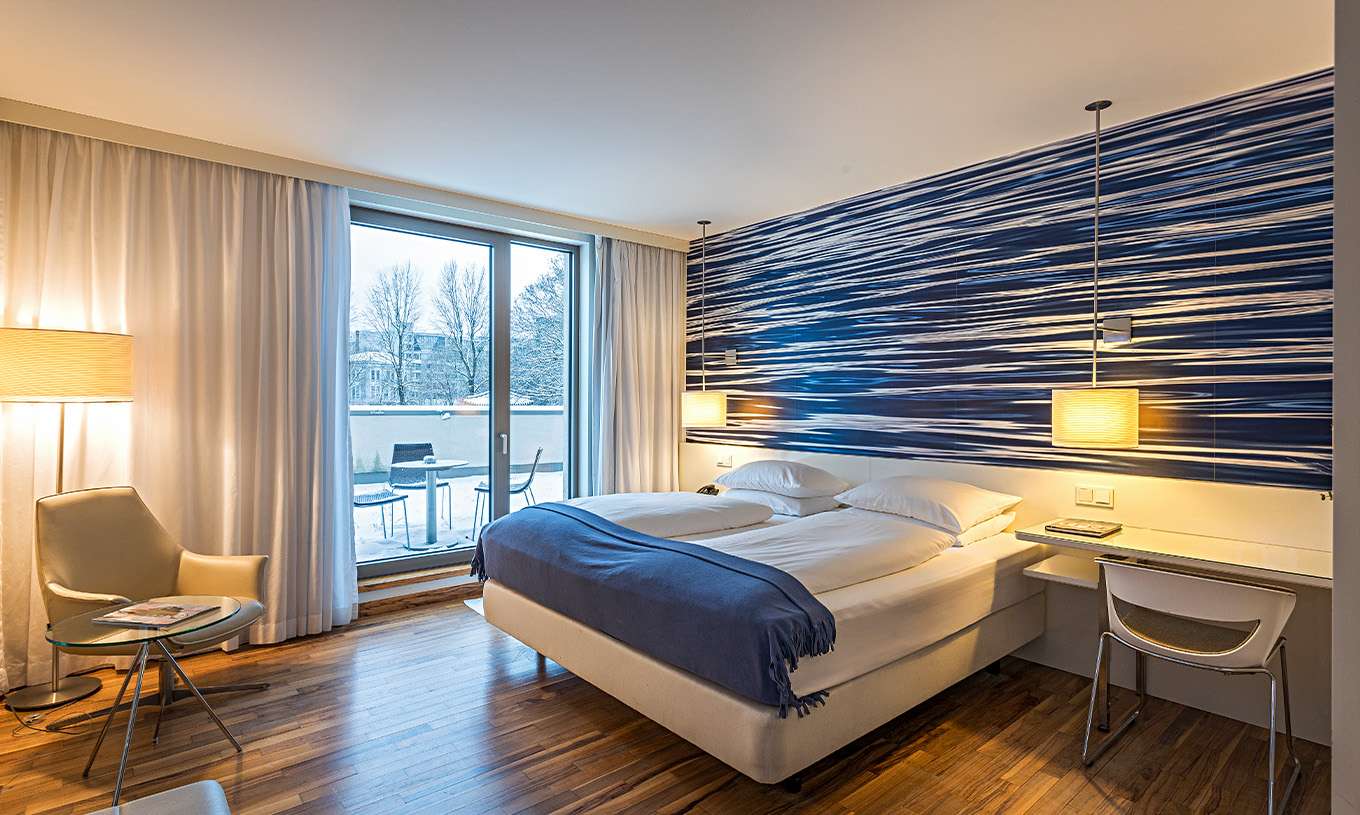 Deluxe Room with Terrace at Pestana Berlin Tiergarten has a double bed, desk and an armchair