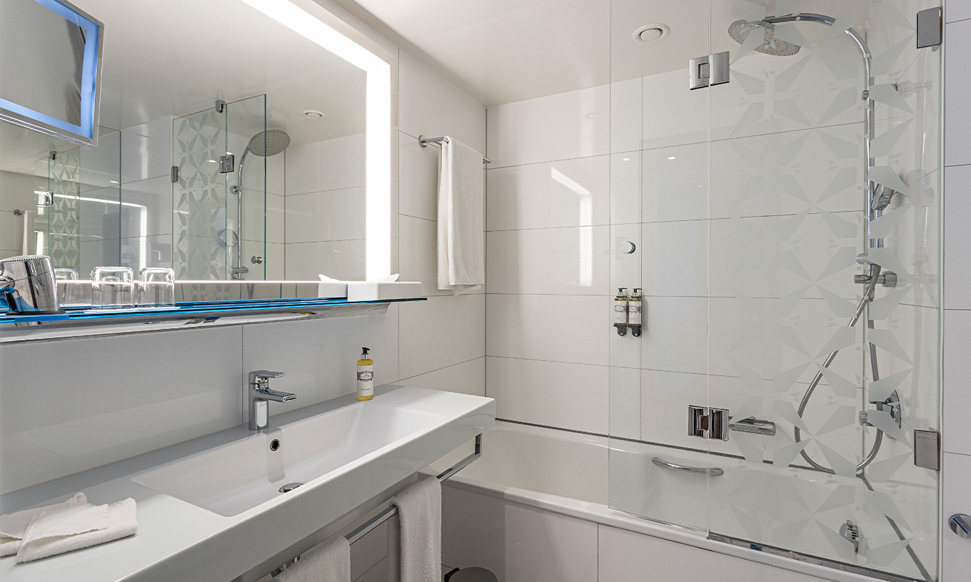 Premium Room with Panoramic Balcony at Pestana Berlin Tiergarten has a bathtub and shower, and sink with mirror