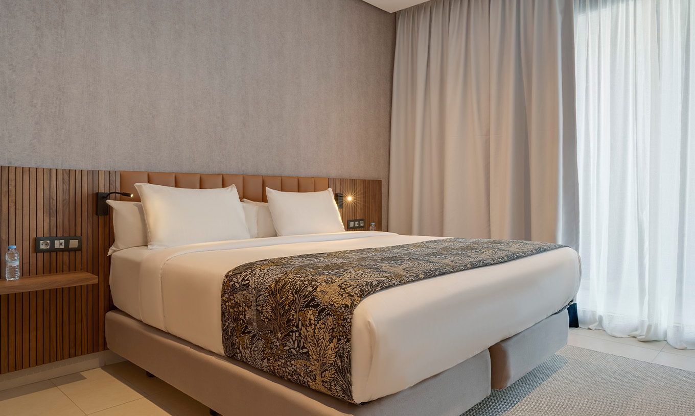 The Family Premium Suite at Pestana Casablanca has a bedroom with a double bed and modern decor