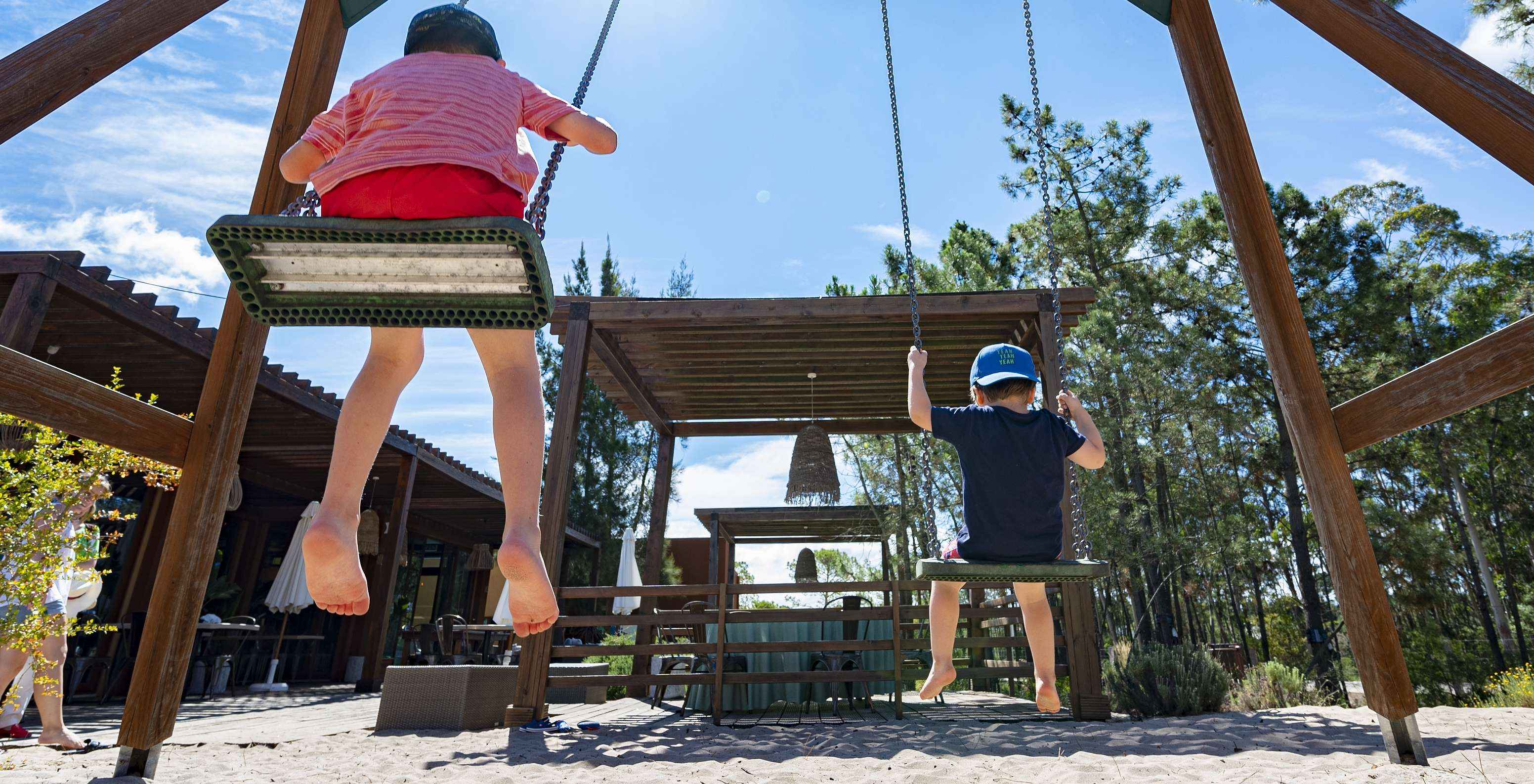 Swing with two children in a small playground near the restaurant at Pestana Tróia Eco Resort