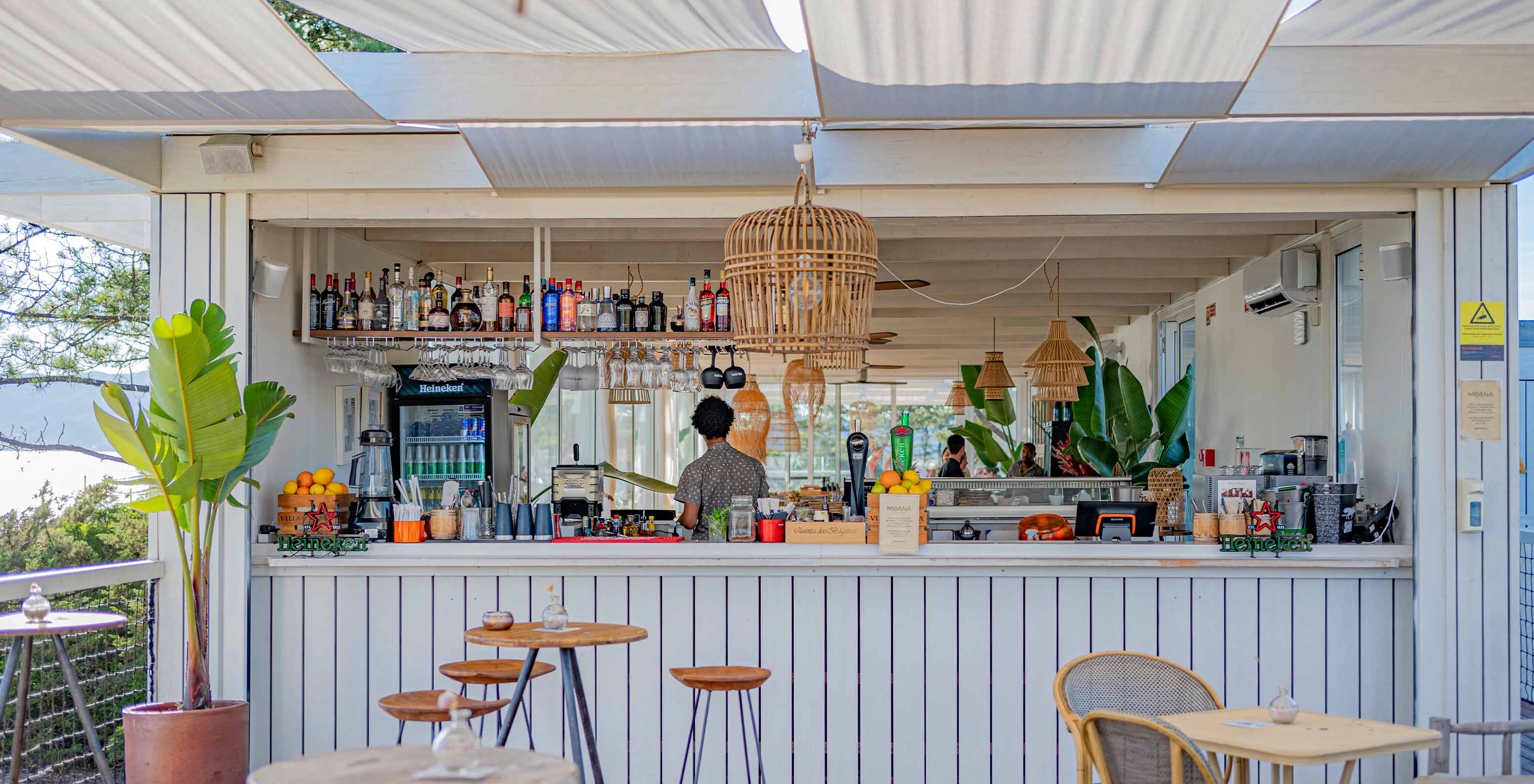 Moana Beach Club bar at Pestana Tróia Eco Resort has wooden tables, chairs, and a drinks counter.