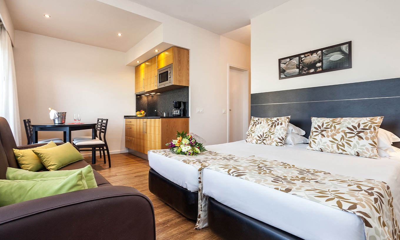 The Garden View Studio at Pestana Alvor Atlântico is an apartment with a bed, sofa, table, and kitchenette