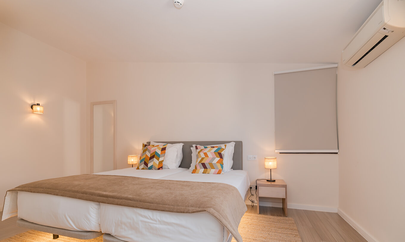 Villa 2 Bedrooms Premium at Pestana Alvor Beach Villas has a bedroom with two beds, bedside table and air conditioning