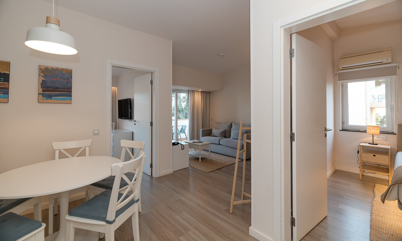 Villa 2 Bedrooms Garden View at Pestana Alvor Beach Villas has a living room with sofa, dining table and two bedrooms