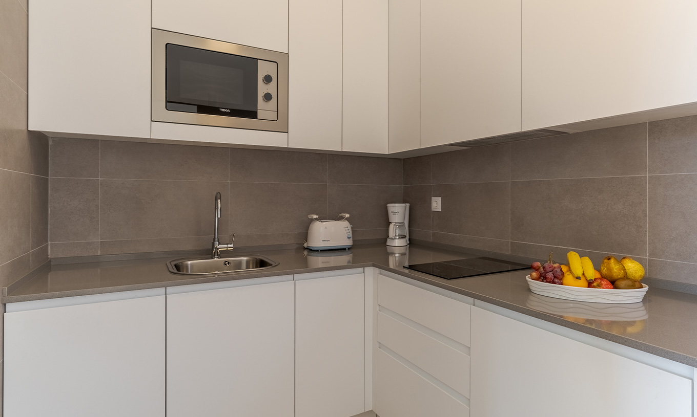 The 3 Bedroom Garden View Villa at Pestana Alvor Beach Villas has a kitchen with a stove and microwave