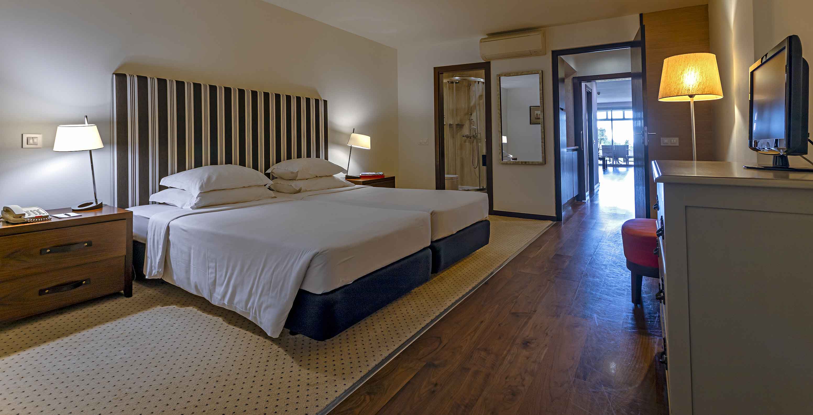 The Cliff Suite T2 at Pestana Alvor Praia has a double bedroom with a bathroom, a television, and air conditioning