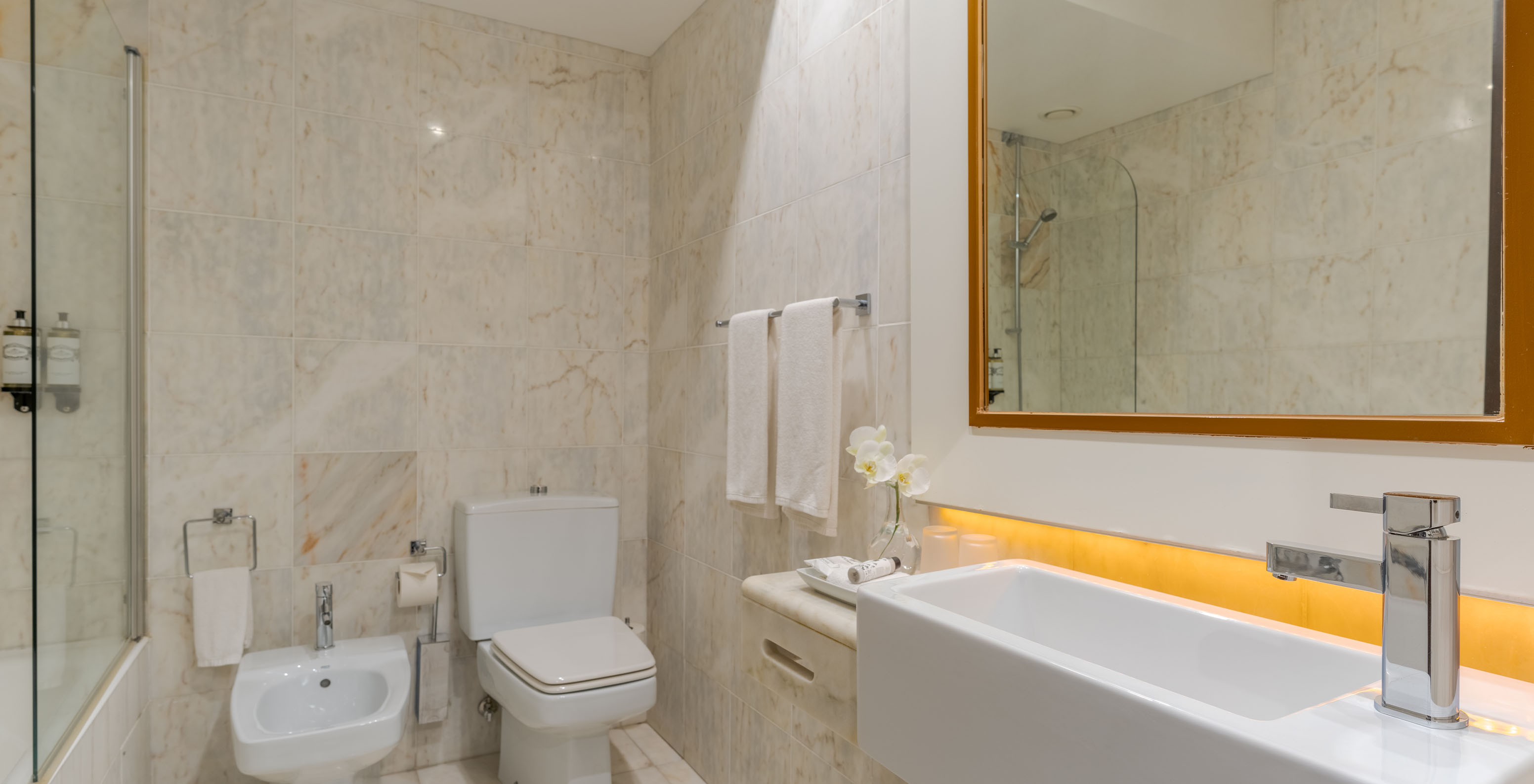 The Garden View Deluxe at Pestana Alvor Praia has a marble bathroom with a sink, mirror, toilet, and bathtub