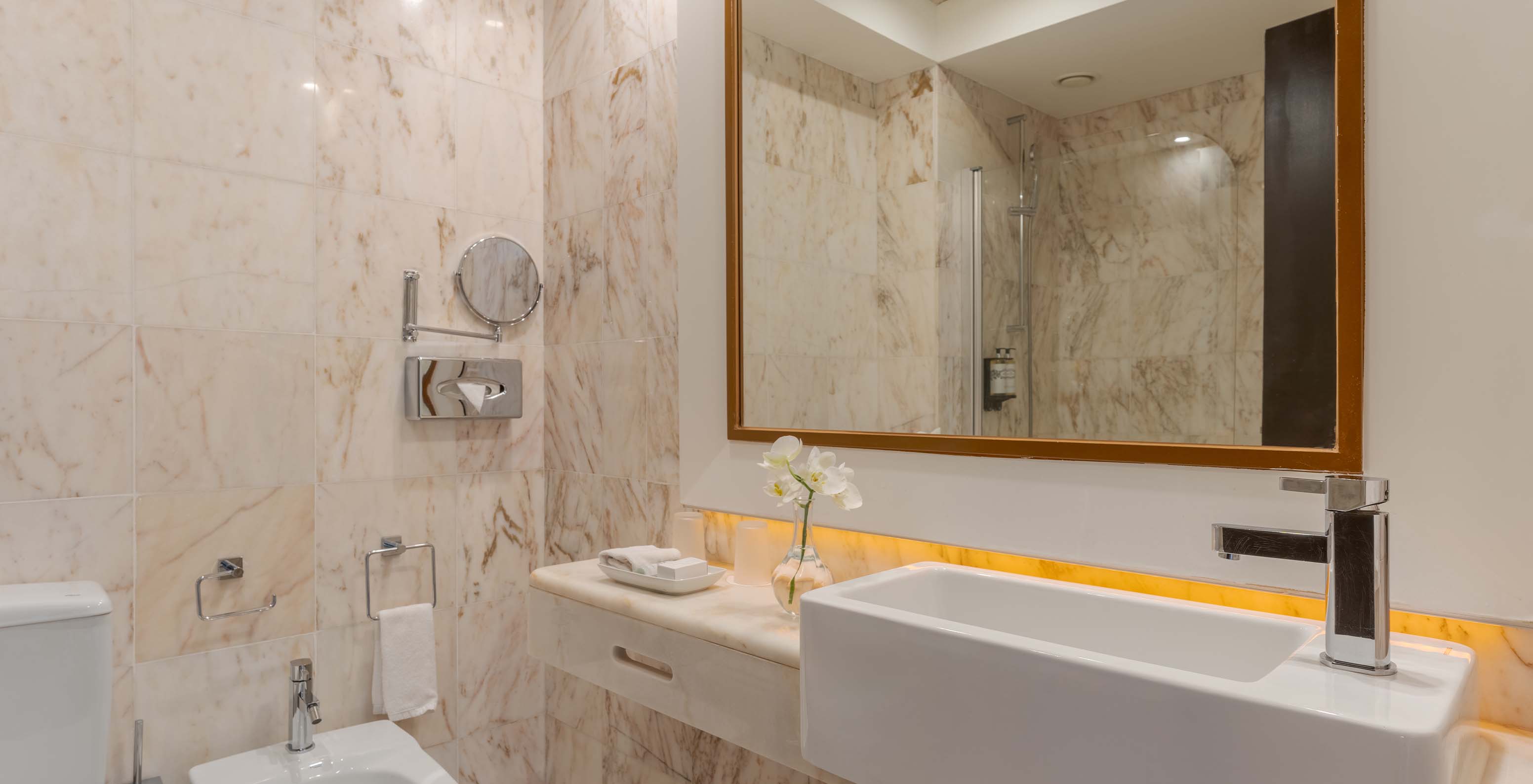 The Garden View Suite at Pestana Alvor Praia has a marble bathroom with bidet, sink, and flower vase