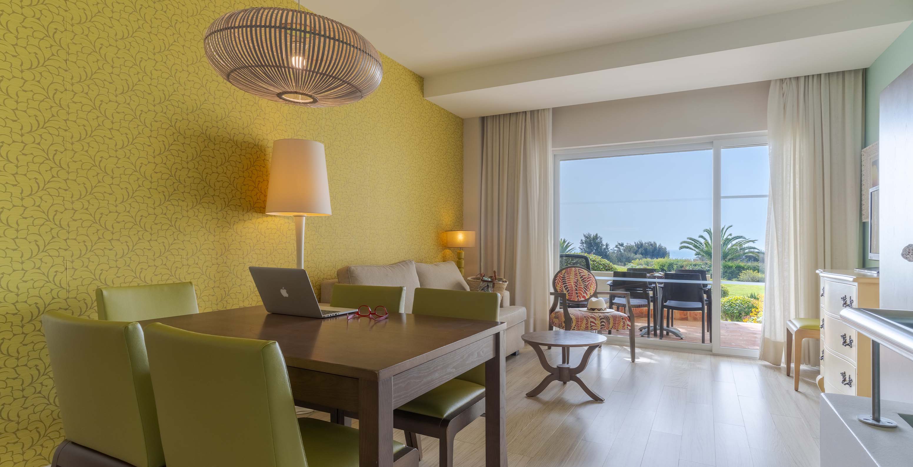 The Duplex Sea View Suite T2 at Pestana Alvor Praia has a living room with a dining table, sofa, and balcony