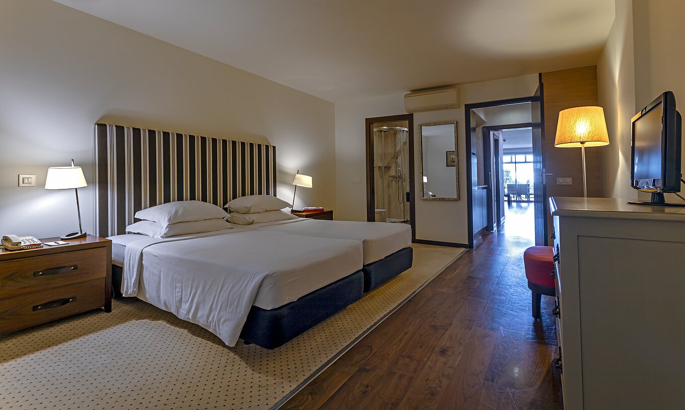 The Cliff Suite T2 at Pestana Alvor Praia has a double bedroom with a bathroom, a television, and air conditioning