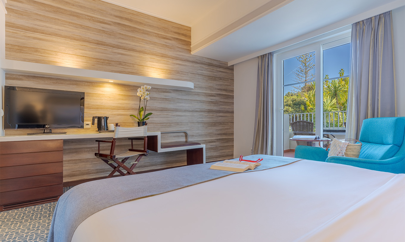 The Garden View Deluxe at Pestana Alvor Praia has a double bed, a desk TV, an armchair, and a window