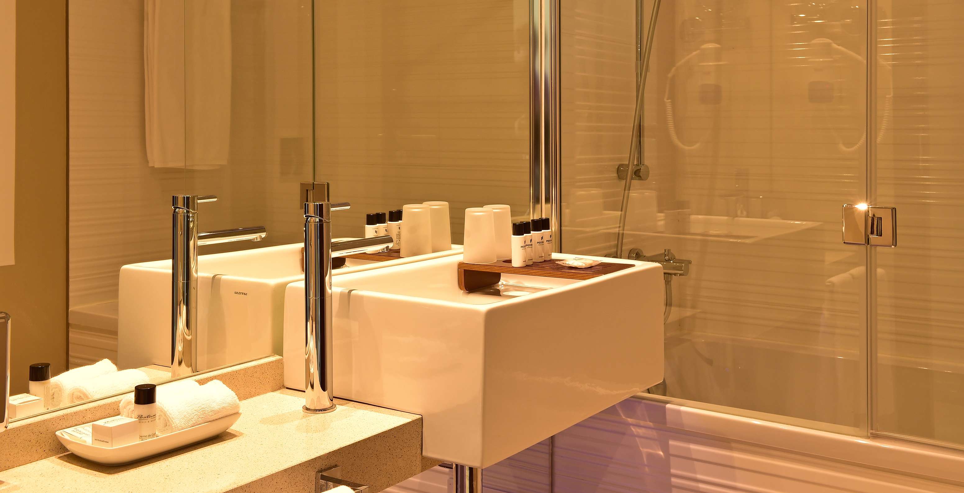 The Suite of Pestana Alvor South Beach has a bathroom with bathtub and shower and a sink with hygiene products