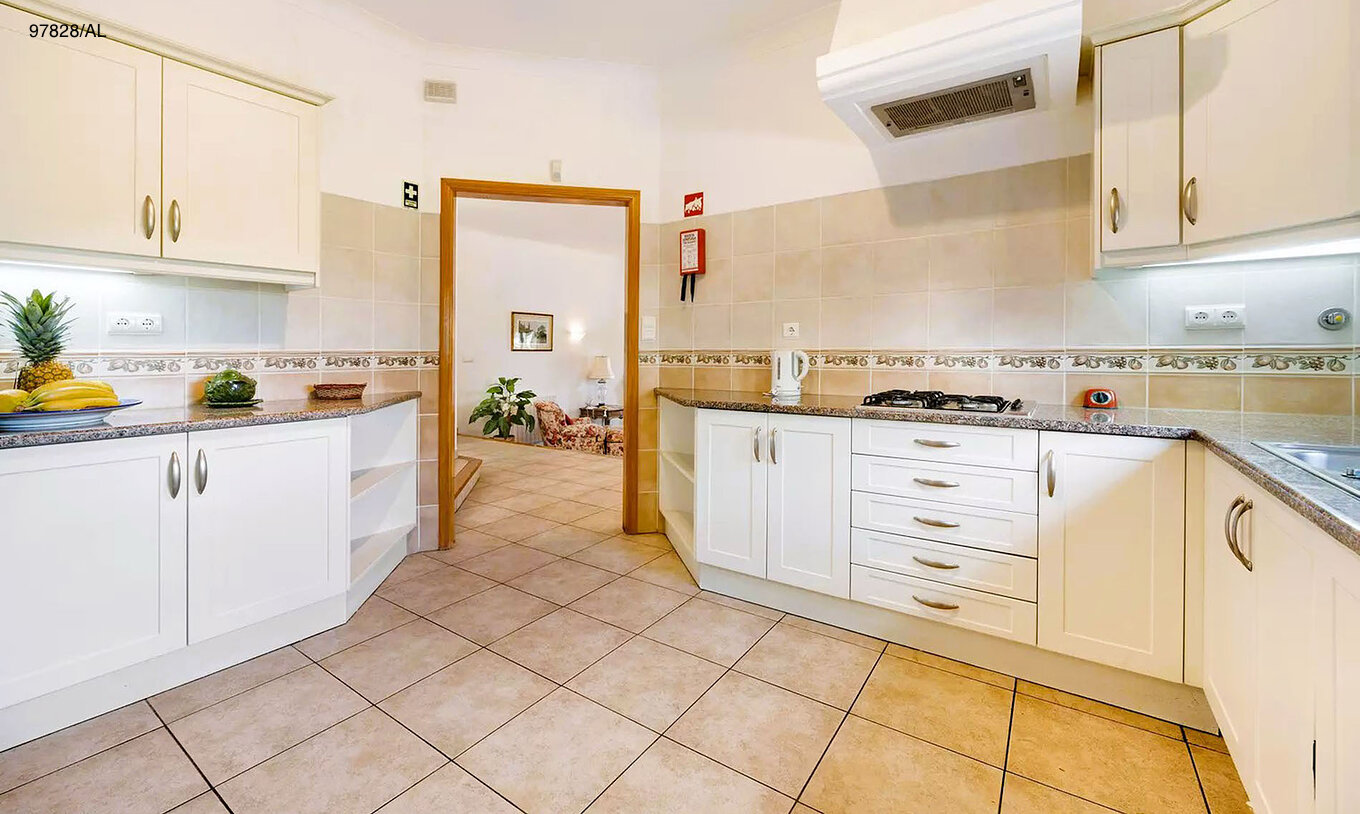 The Pestana Carvoeiro Golf V3 Standard Villa has a kitchen equipped with white cabinets and appliances