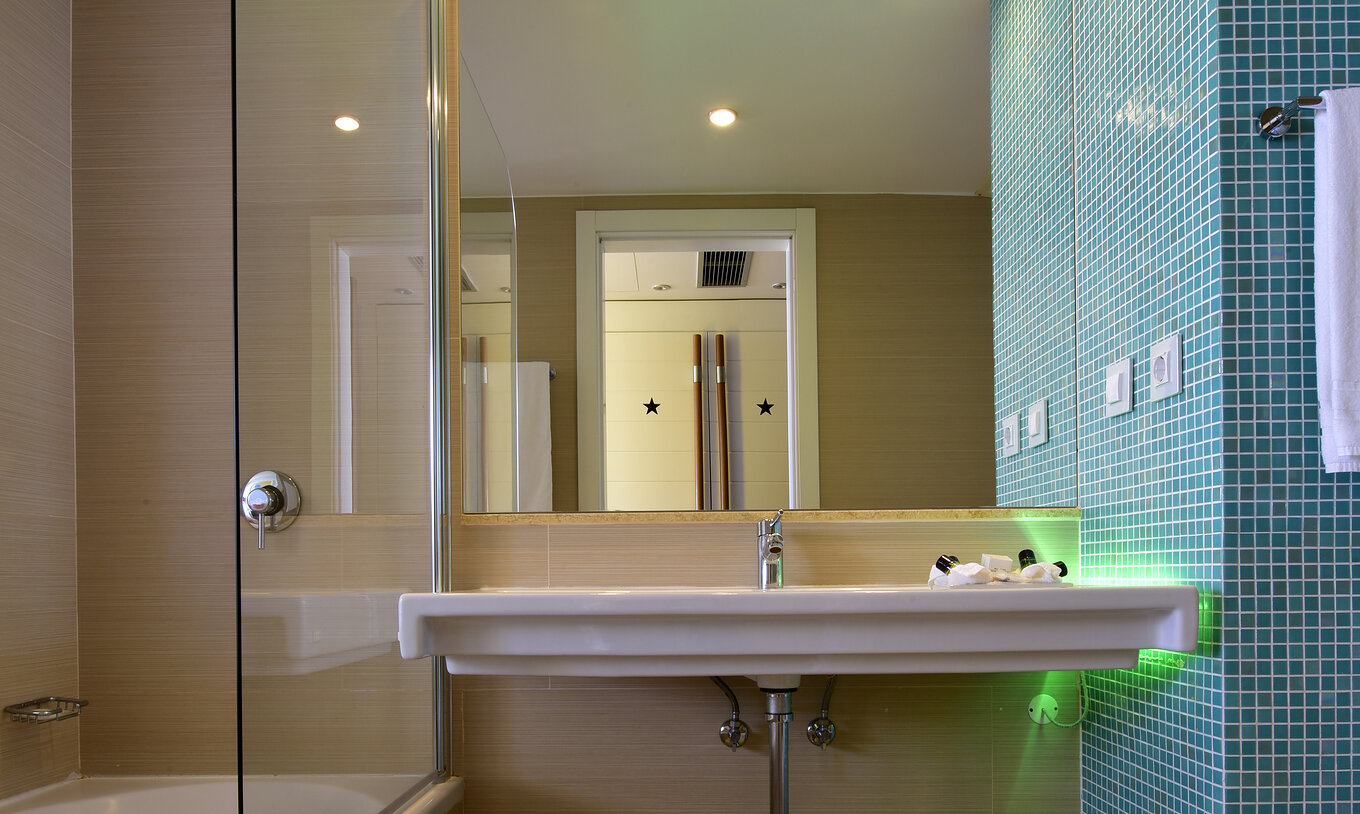 The Deluxe Sea View at Pestana Dom João II features a bathroom with a sink, mirror, and bathtub with shower