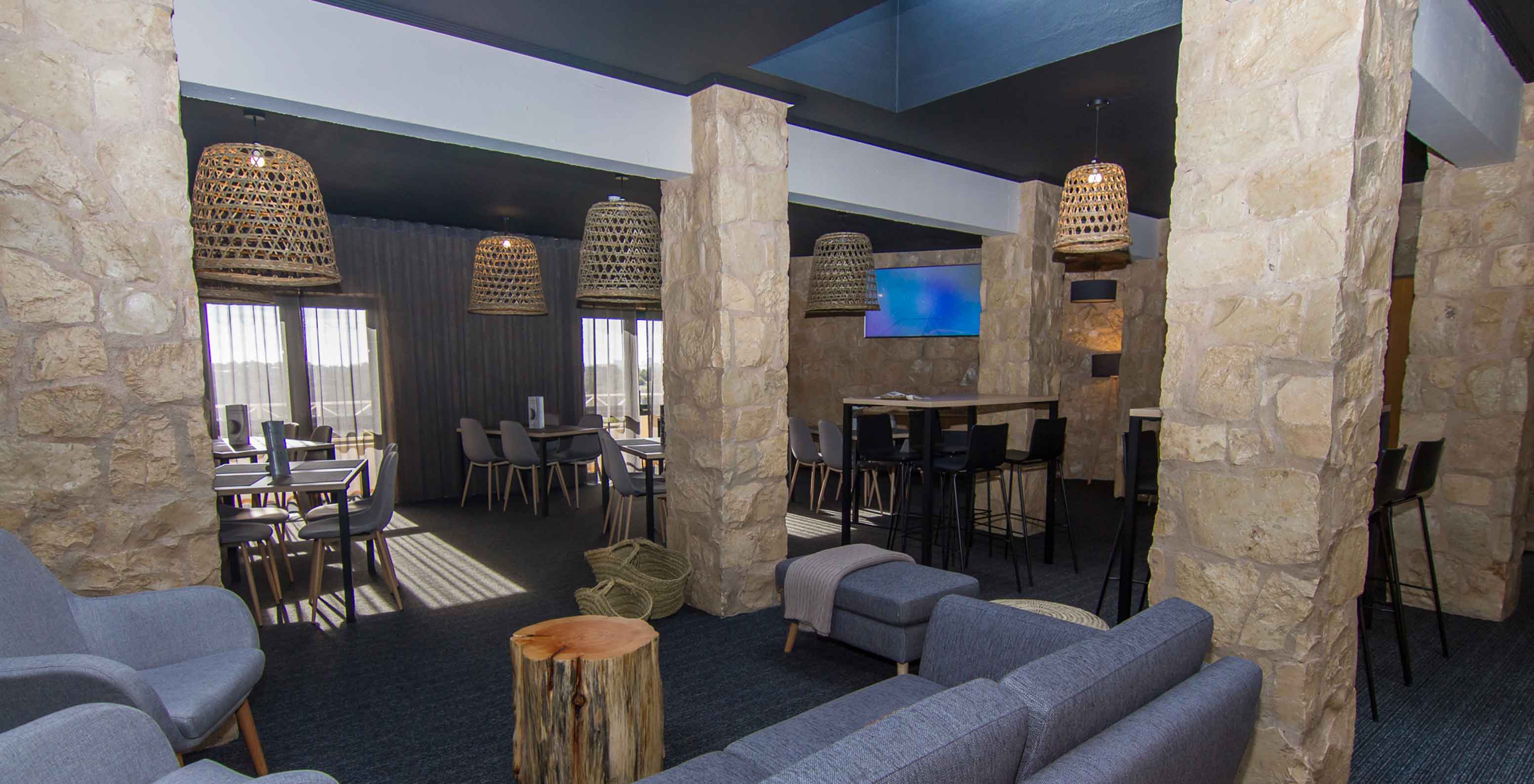 The Fairway Restaurant, of the 4-Star Family Hotel in Algarve, has a space with lamps, tables, and chairs