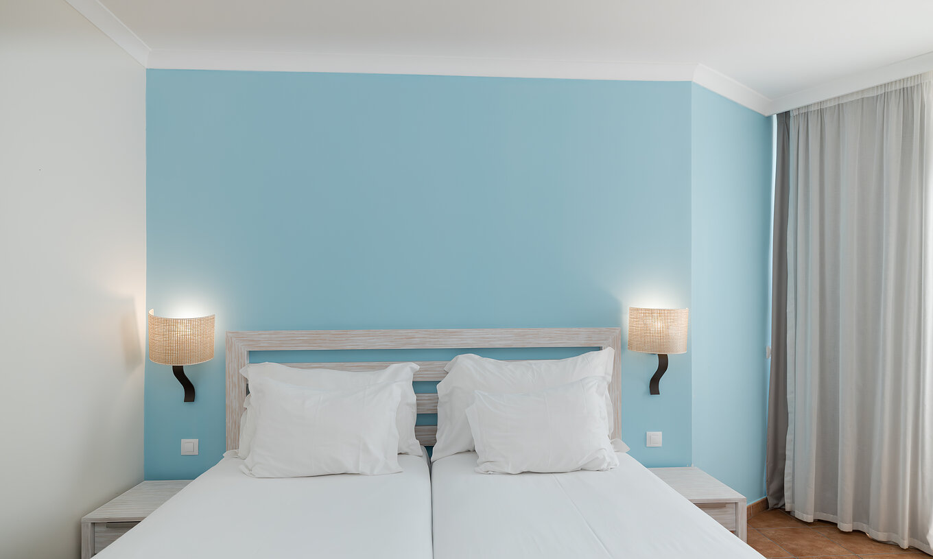The Deluxe room at Pestana Viking features two single beds with lamp and bedside table