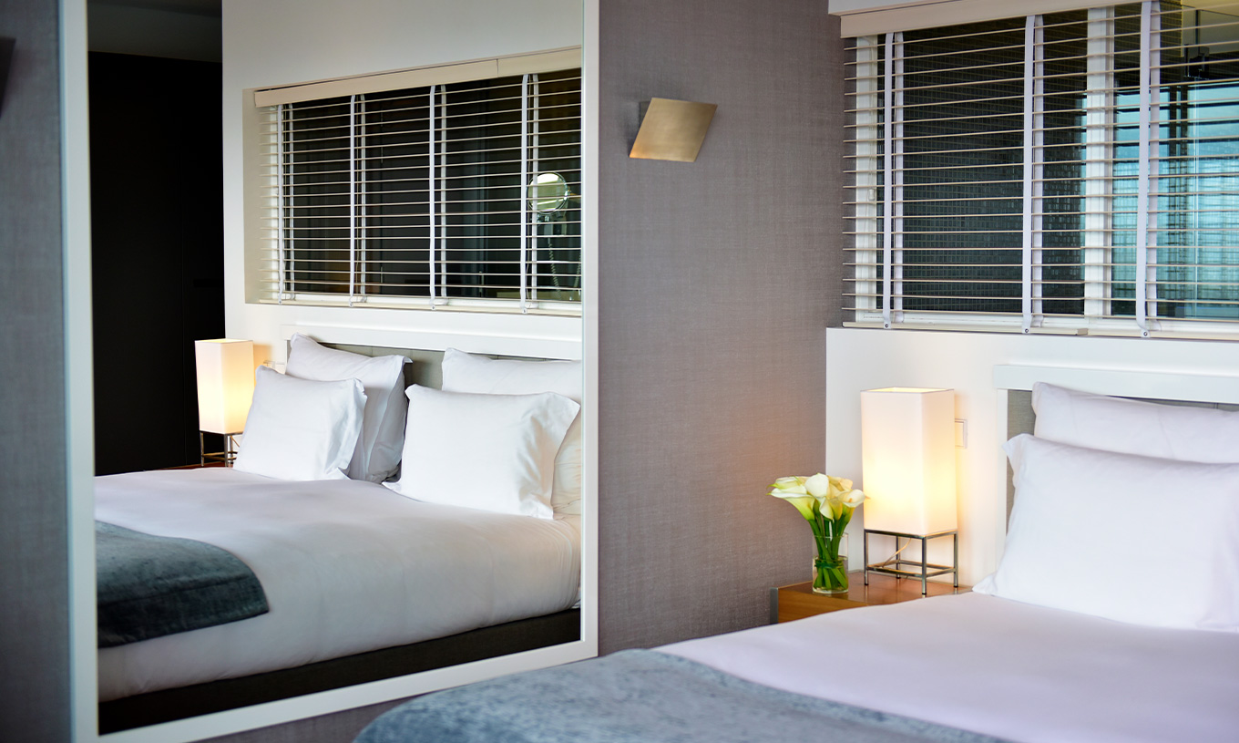 The Suite at Pestana Cidadela Cascais has a double bed, a bedside table, and a large mirror