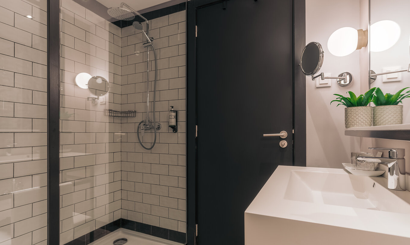 The Rooftop Junior Suite at Pestana Lisboa Vintage has a bathroom with shower with glass doors and two mirrors