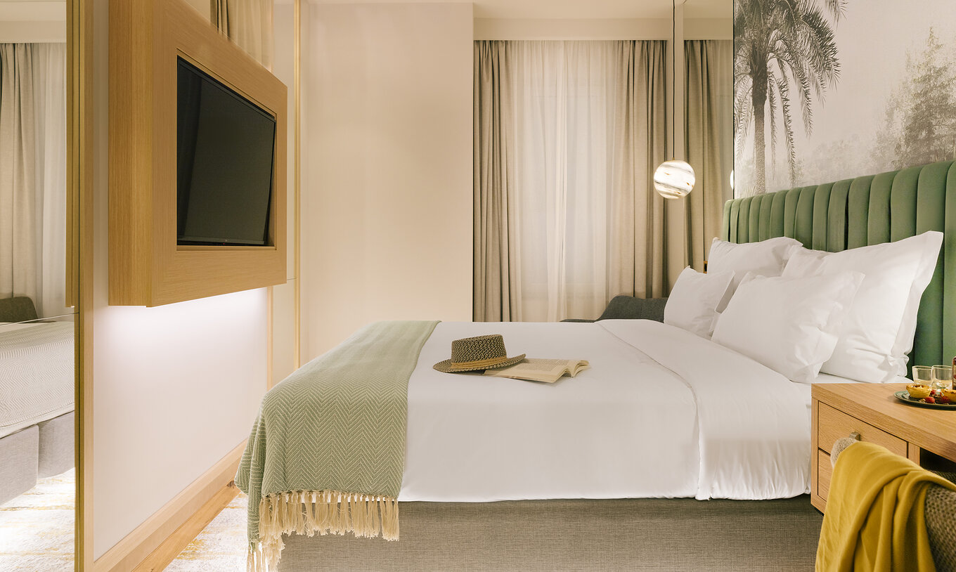The Comfort Interior of Pestana Rua Augusta Lisboa has a double bed with television in front and a window with curtains
