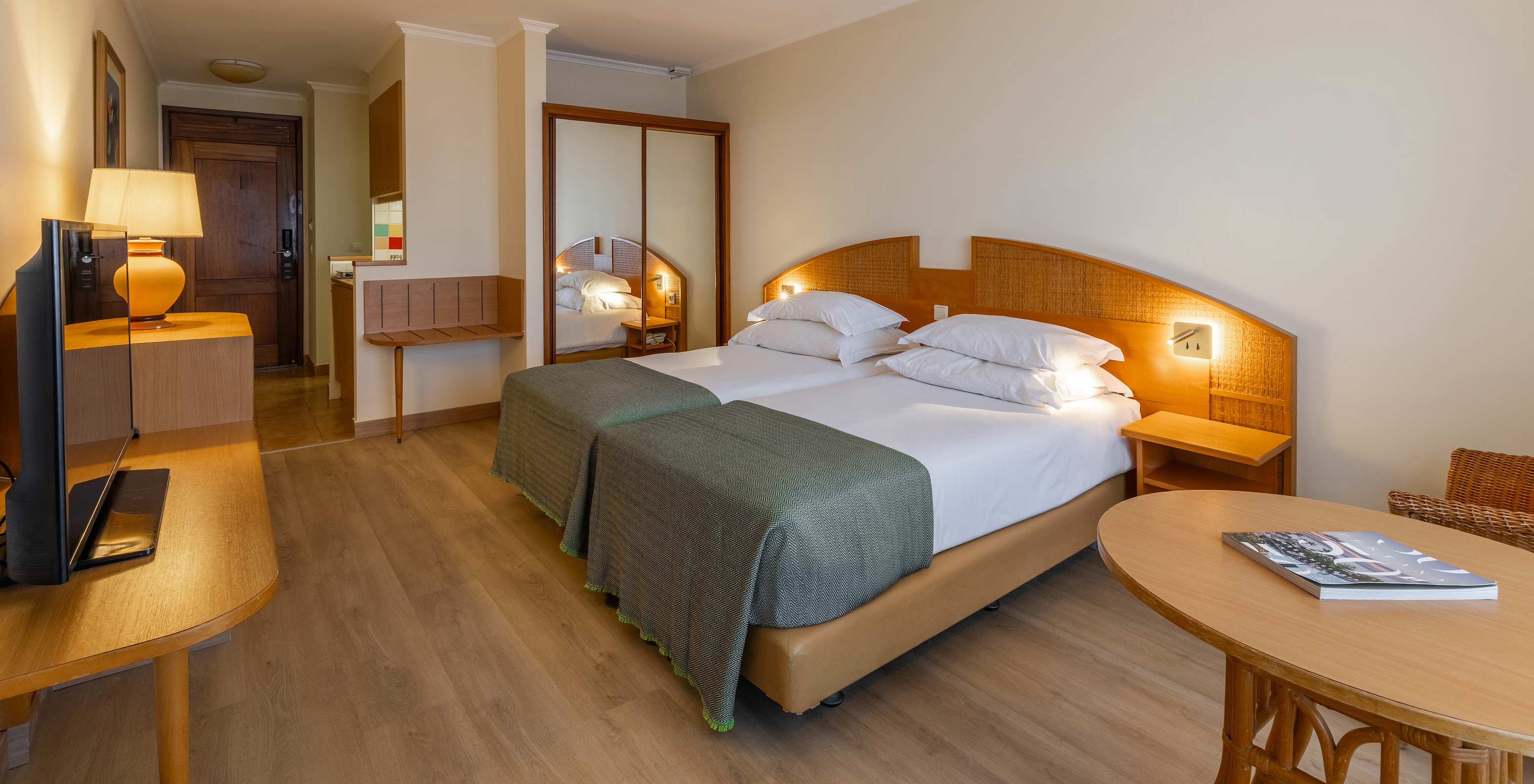 The Pestana Ocean Bay All Inclusive Classic Sea View has two single beds joined together, a wardrobe with a mirror and a TV
