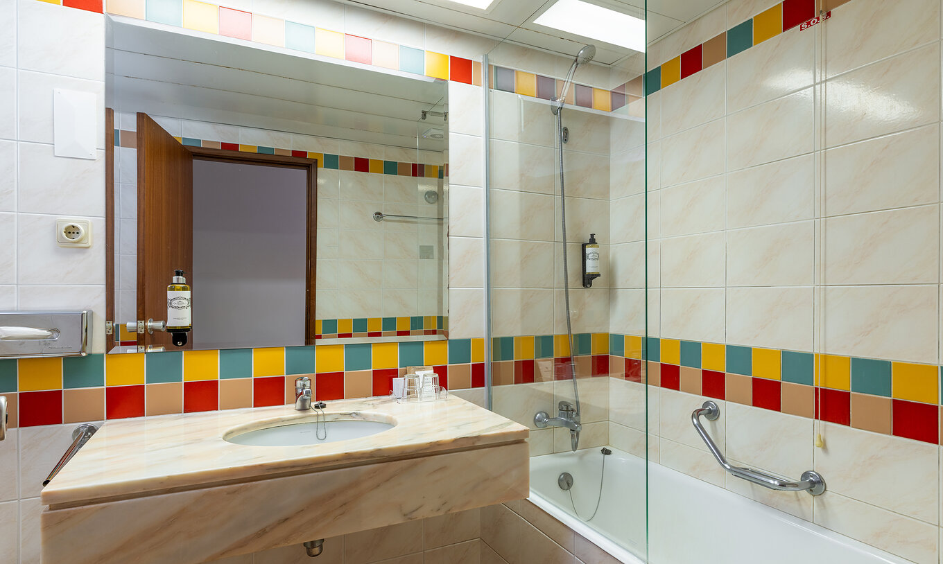 The Pestana Ocean Bay All Inclusive Classic Sea View has a bathroom with a bathtub and a washbasin with a mirror