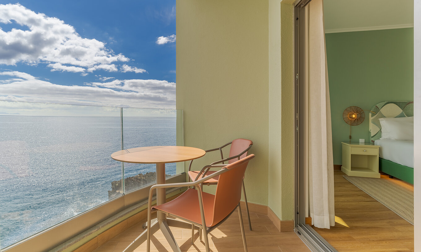 The Classic Sea View room at Pestana Vila Lido Madeira features a balcony with a table, chairs, and sea view
