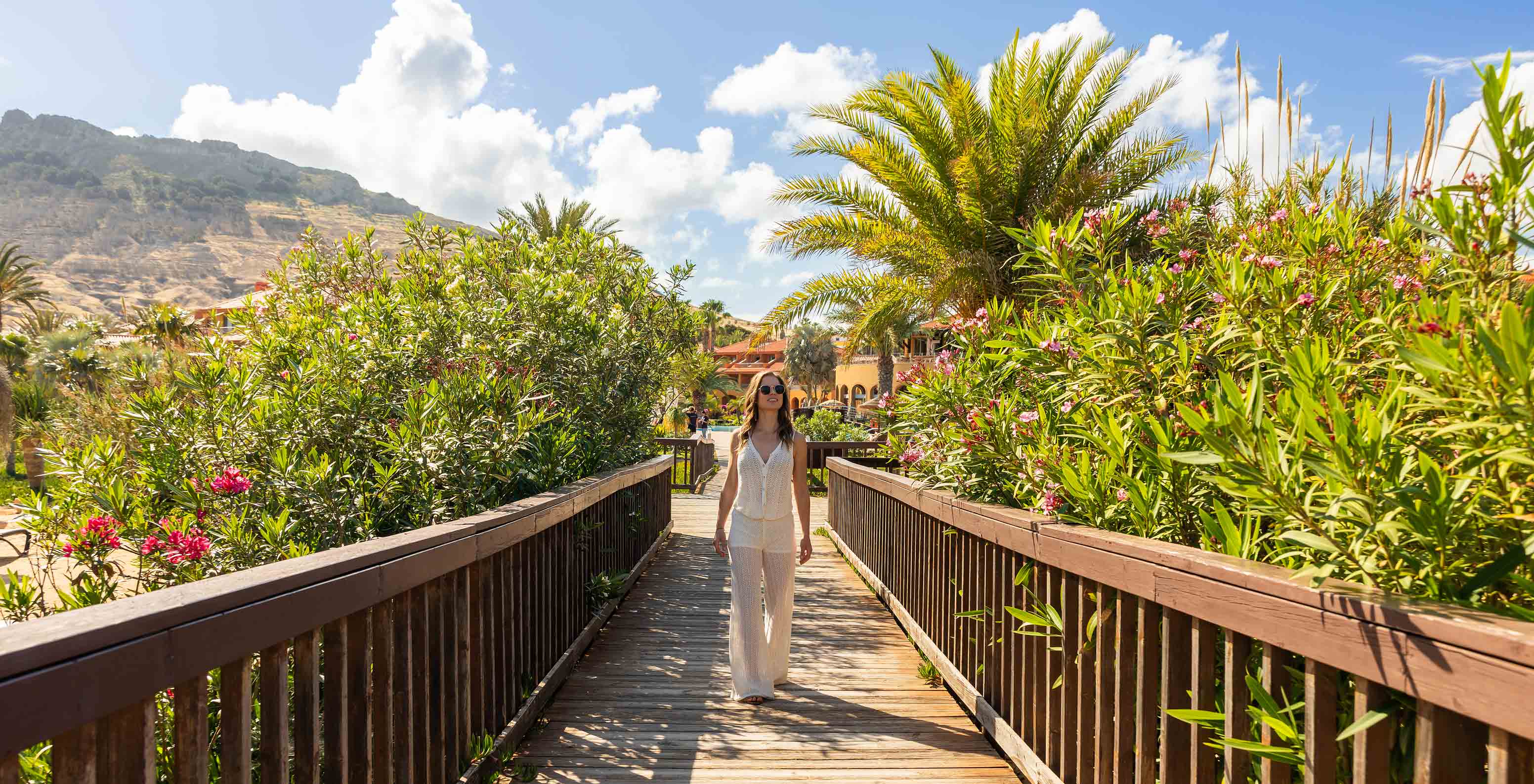 Guest surrounded by vegetation while walking along the walkways of Pestana Porto Santo All Inclusive