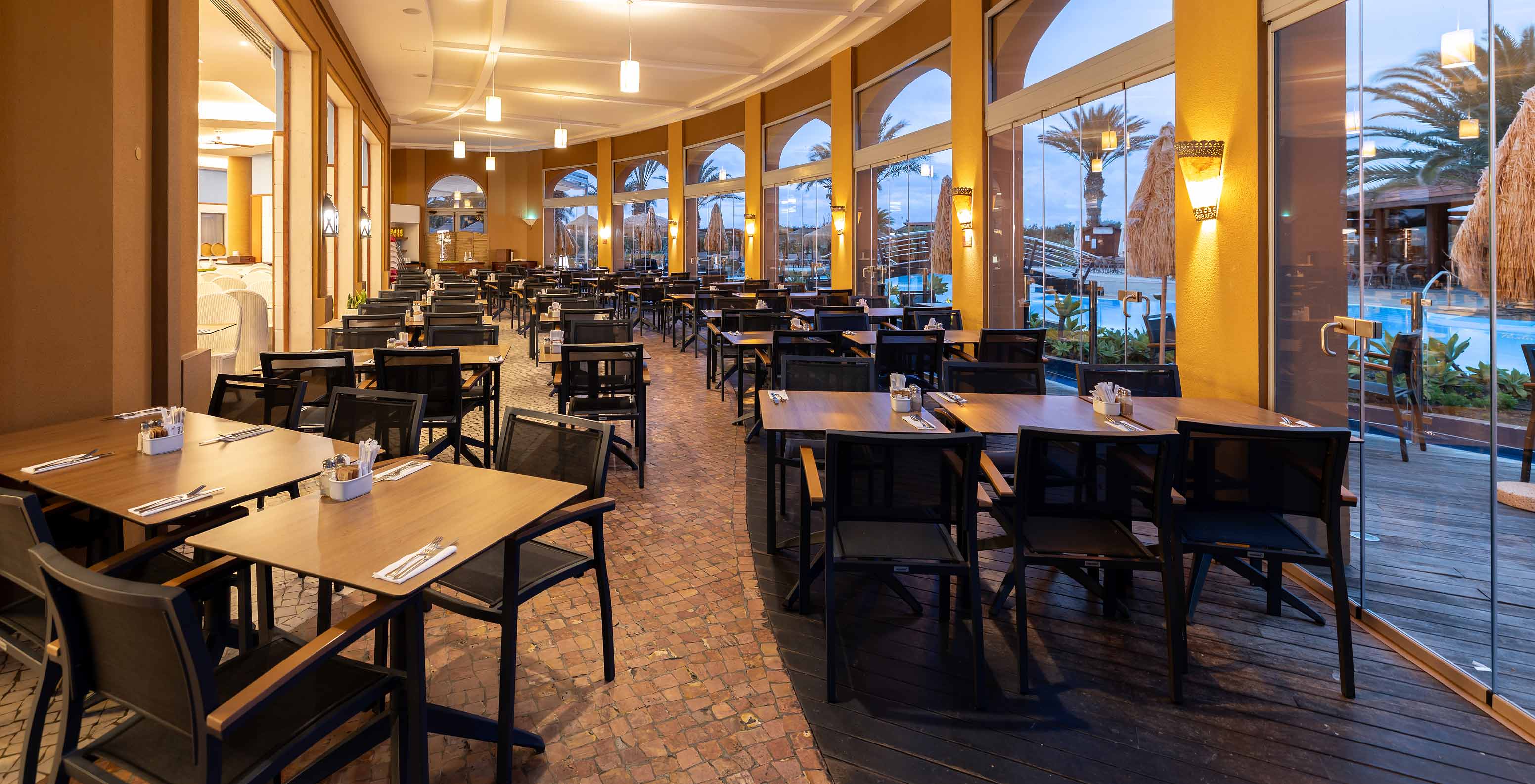 The Marés restaurant at the 5-star Resort in Porto Santo has an outdoor area with square tables and chairs.