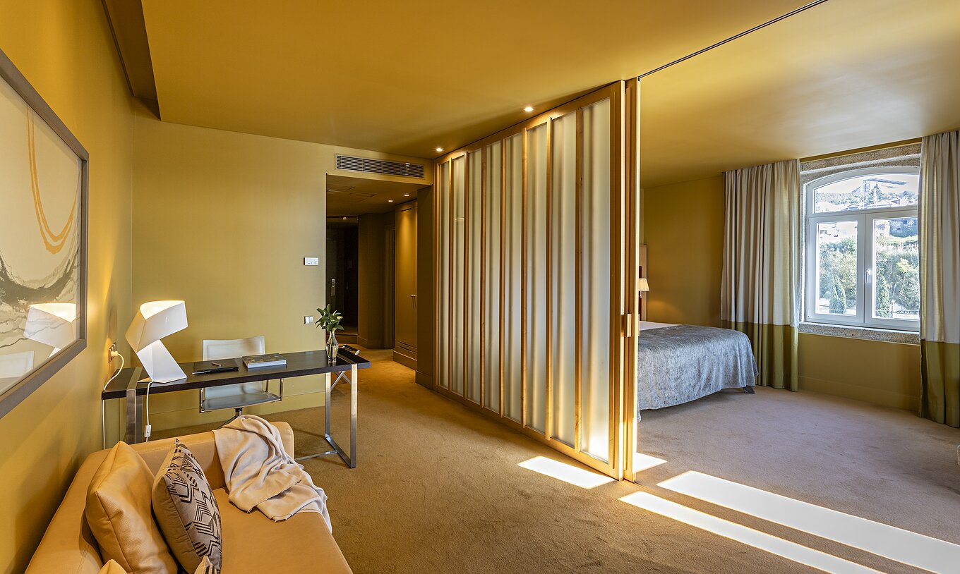 The Standard Suite has a double bed with a partition to the living room with sofa and desk