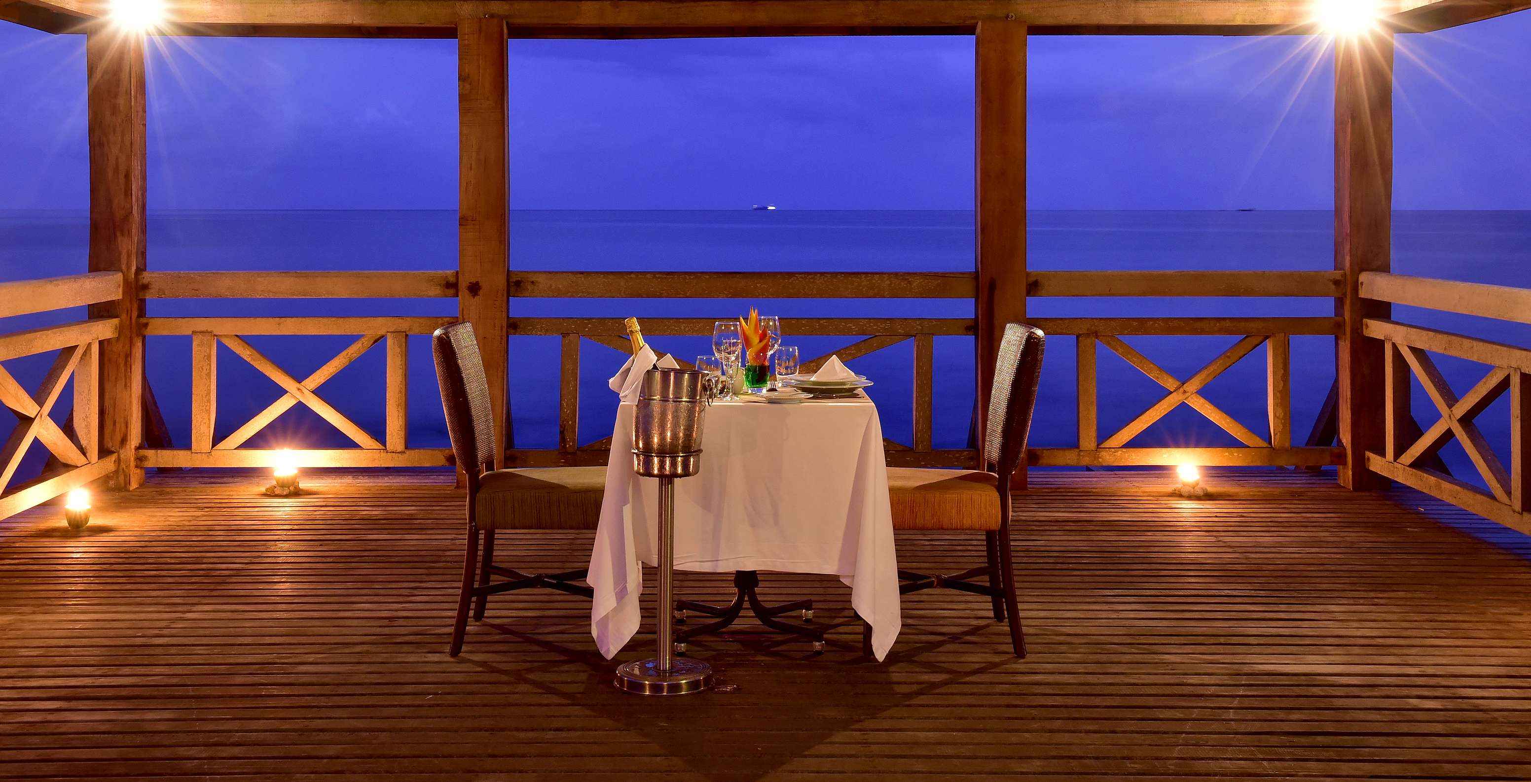 Table set for a romantic dinner for two on the wooden pier over the sea at Pestana São Tomé