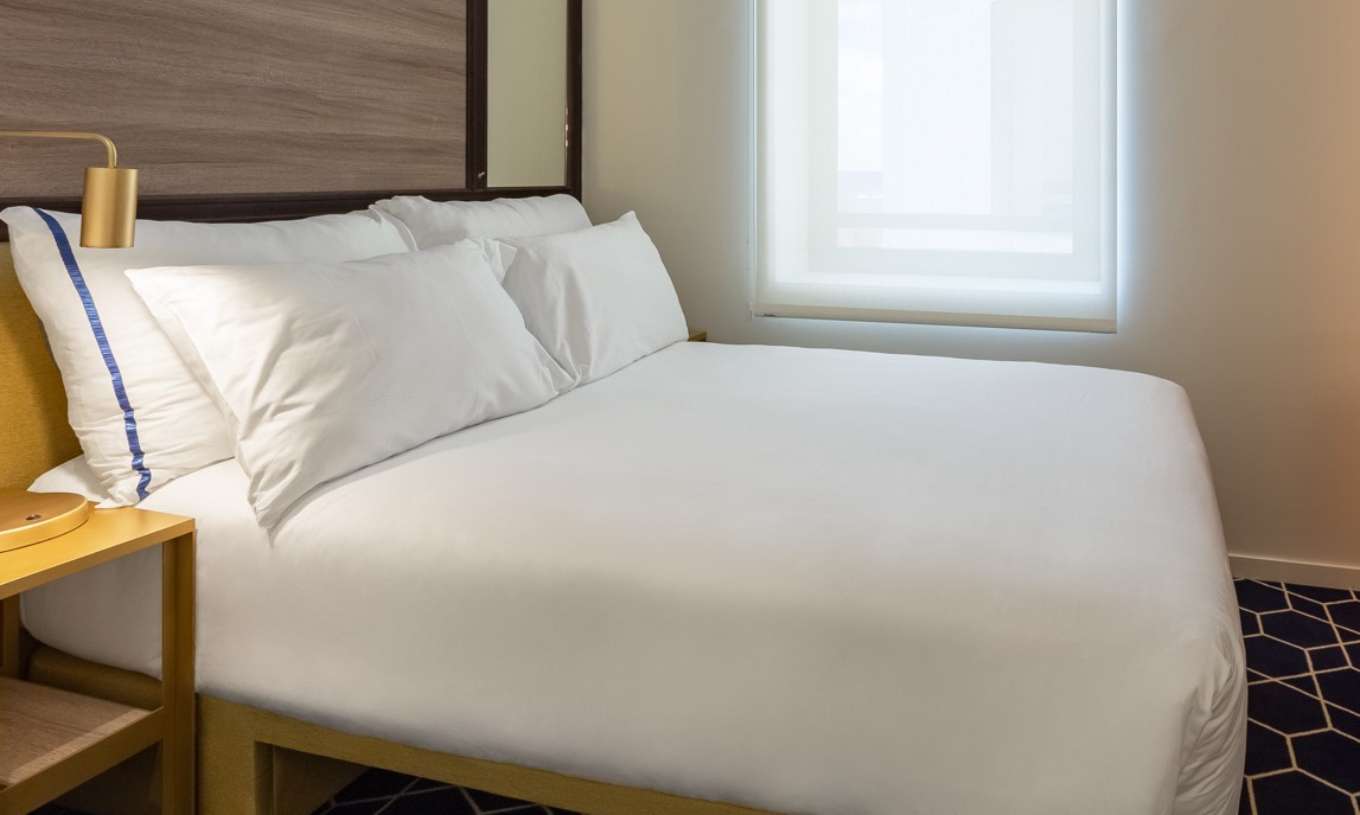 The Small Double Room at Pestana CR7 Gran Vía Madrid has a double bed, a window, and a yellow bedside table