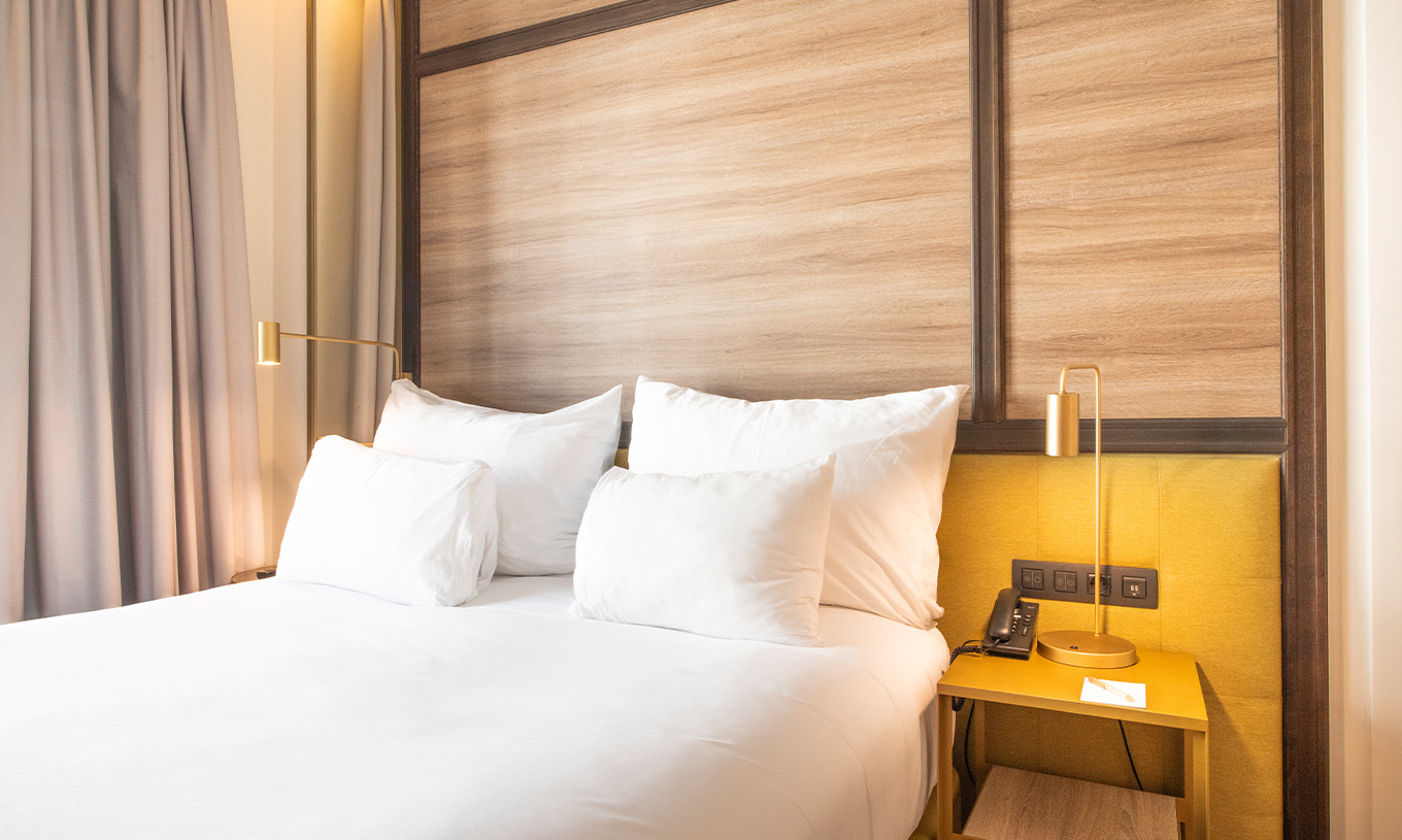 The Legend Room at Pestana CR7 Gran Vía Madrid has a double bed, bedside table, and two golden lamps