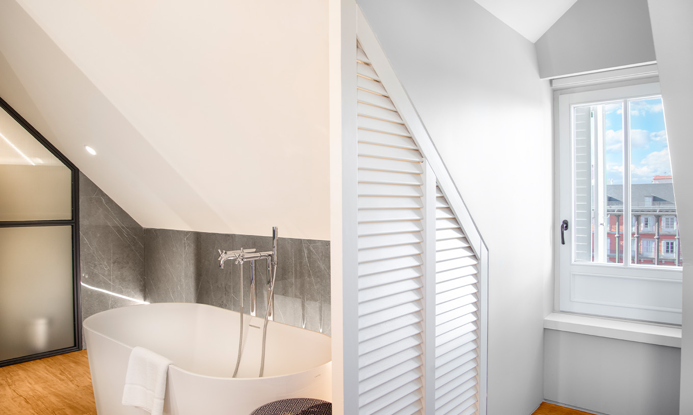 The Suite Plaza Mayor at Pestana Plaza Mayor Madrid has a bathroom with bathtub and window with a view of Plaza Mayor