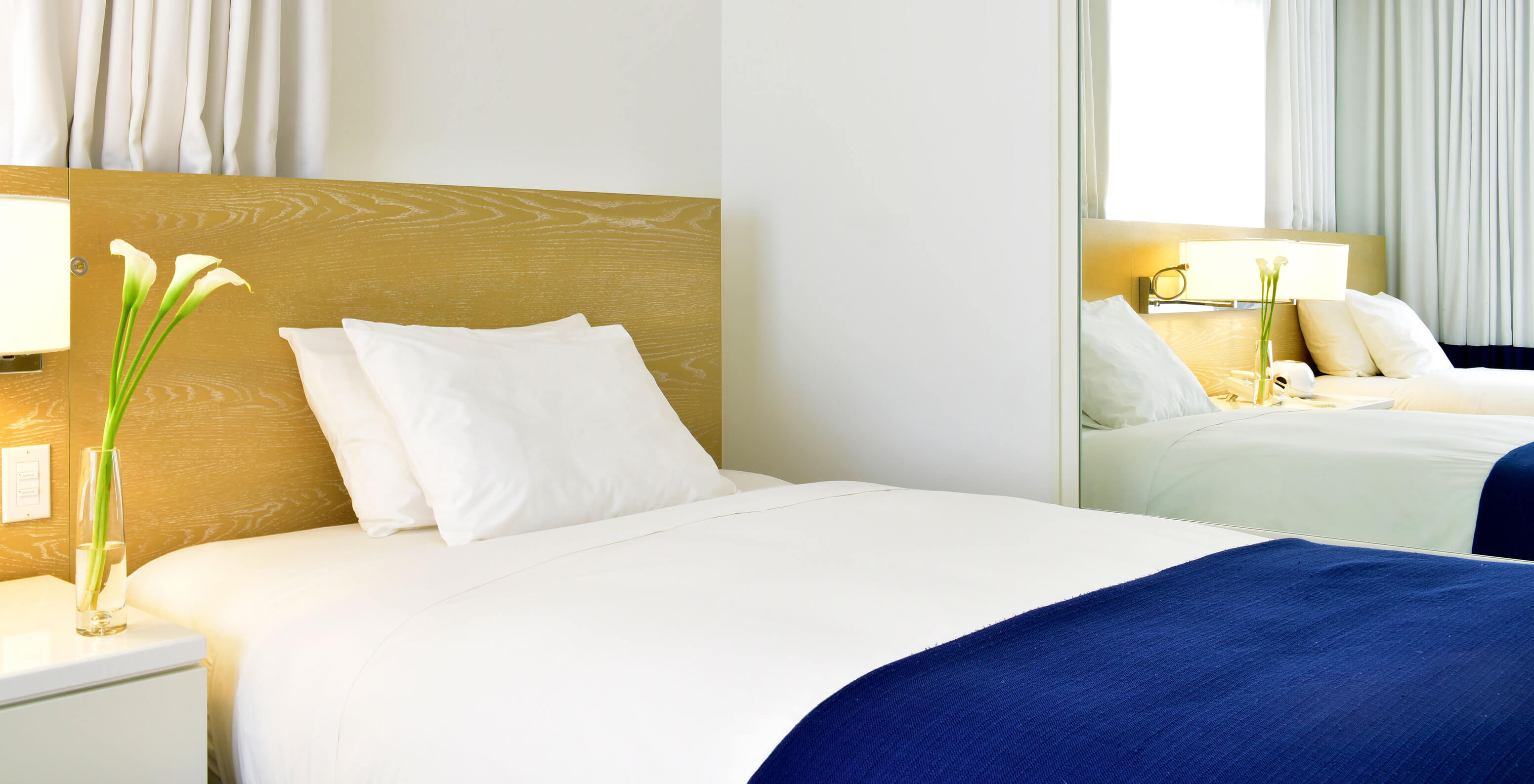 The Classic Double Beds at Pestana Miami South Beach has a bed and a large mirror