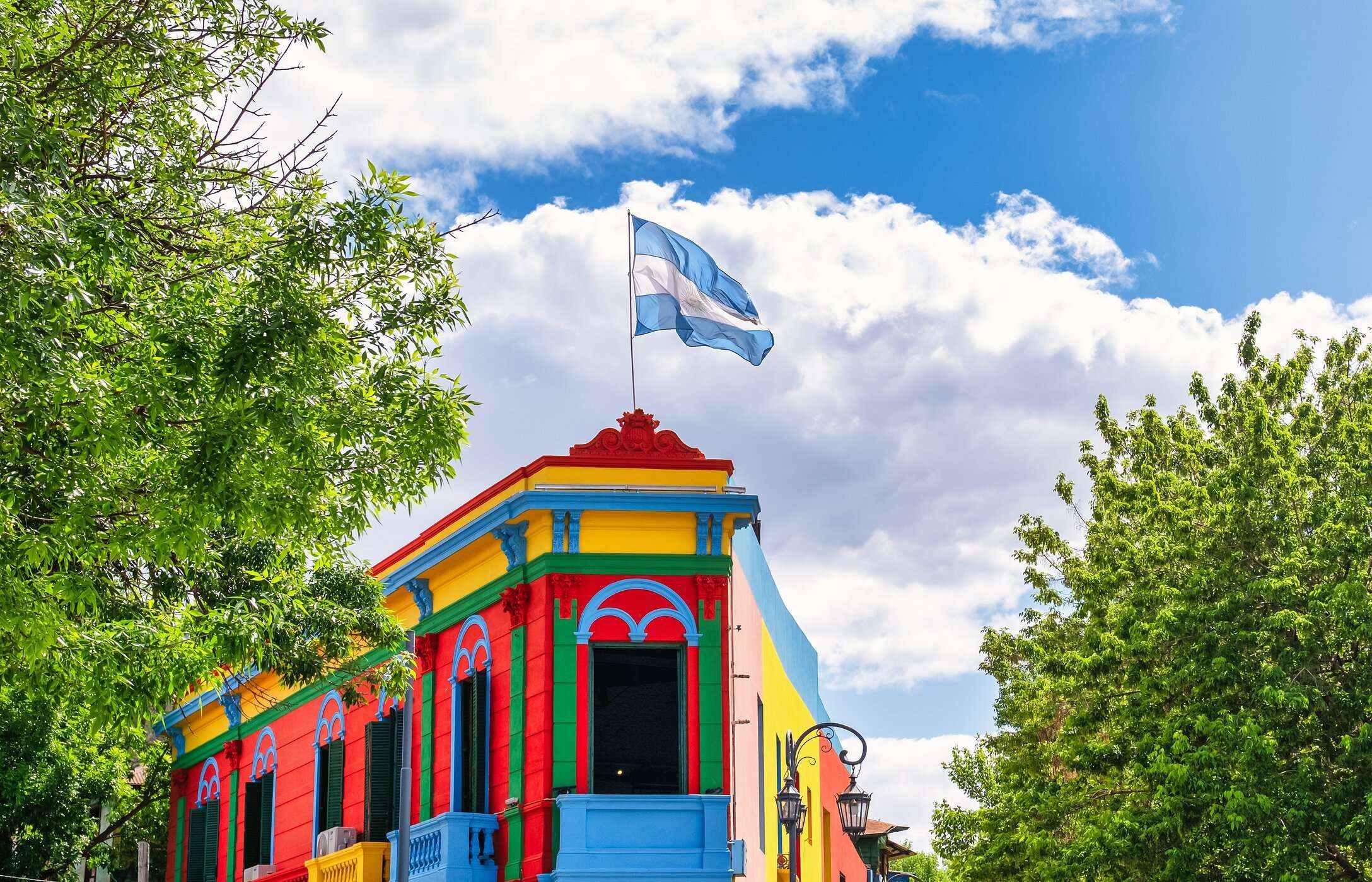 Colorful buildings of the typical Caminito neighborhood in Buenos Aires, with the Argentine flag